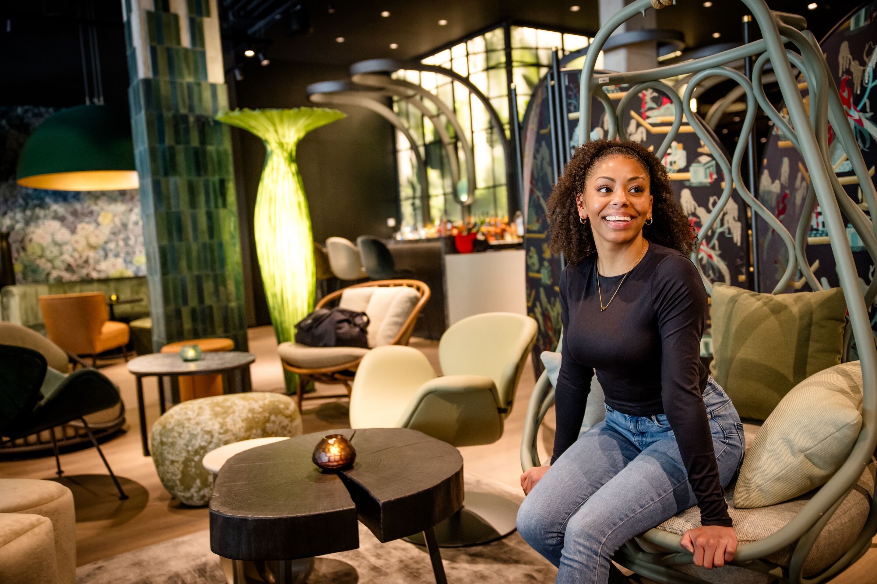 Designhotel München Hauptbahnhof Motel One lachende Frau auf einem Sessel in der Lounge