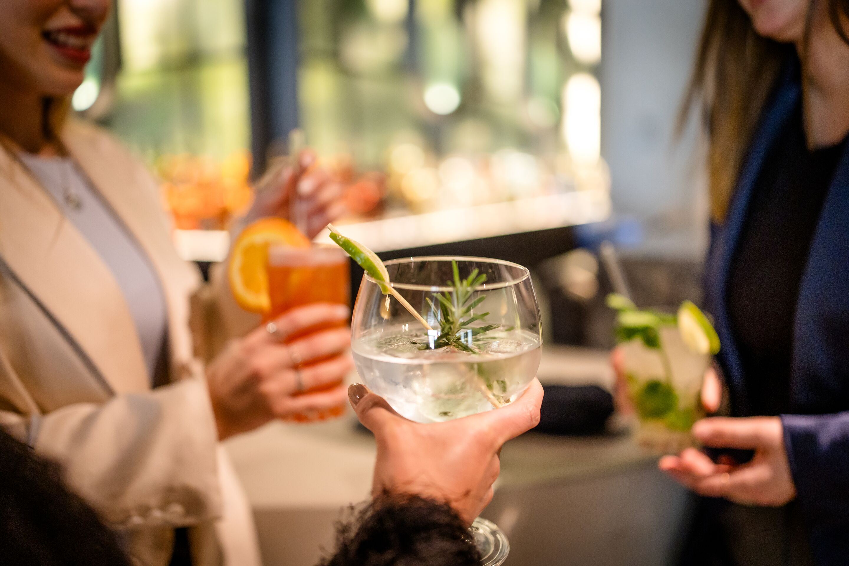 Designhotel München Hauptbahnhof Motel One mehrere Personen stoßen mit Getränken in den Händen an Designhotel München Hauptbahnhof Motel One mehrere Personen stoßen mit Getränken in den Händen an