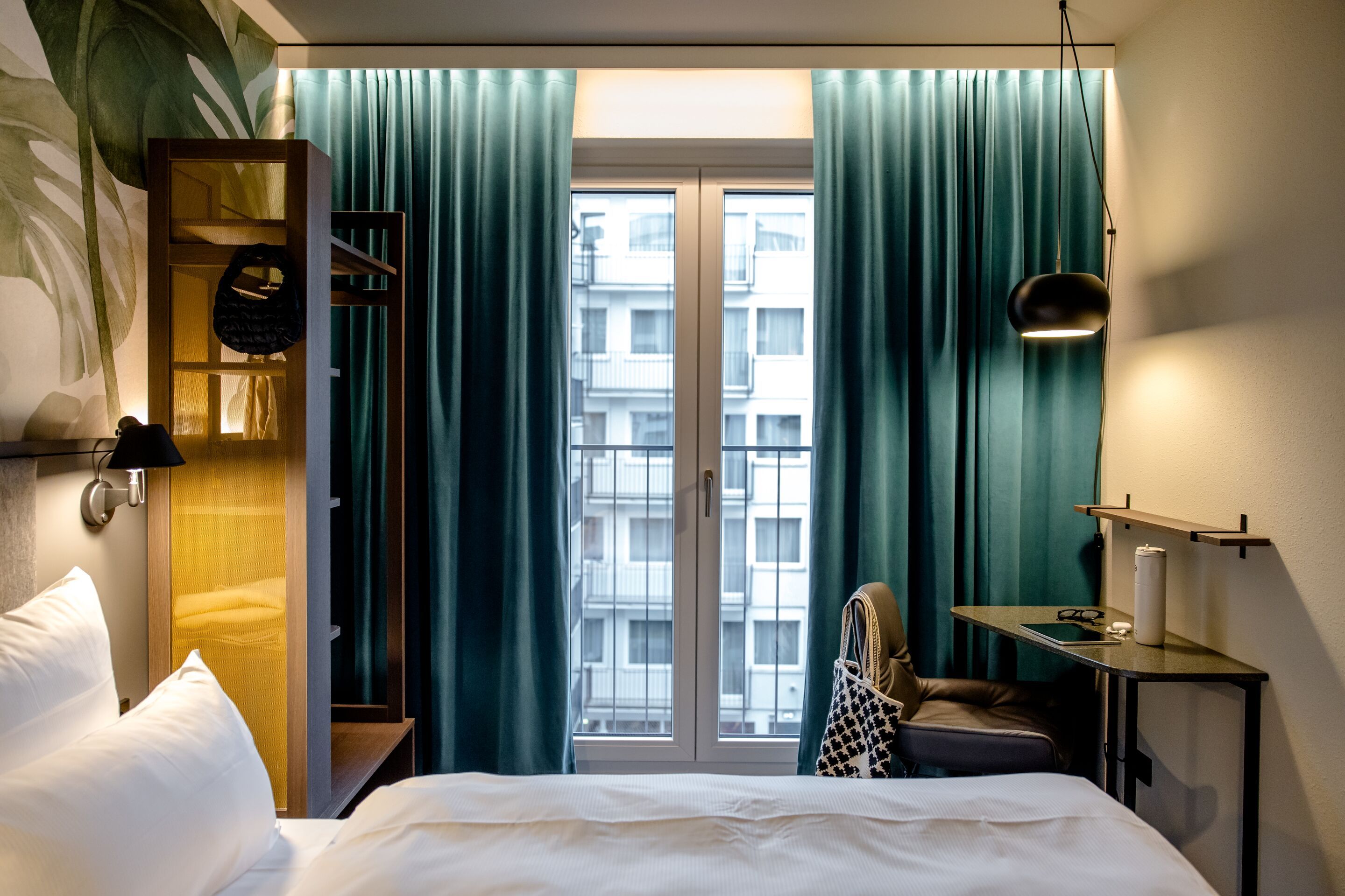 Hotels München Hauptbahnhof Motel One Zimmer mit seitlichem Blick über Bett auf bodentiefes Fenster