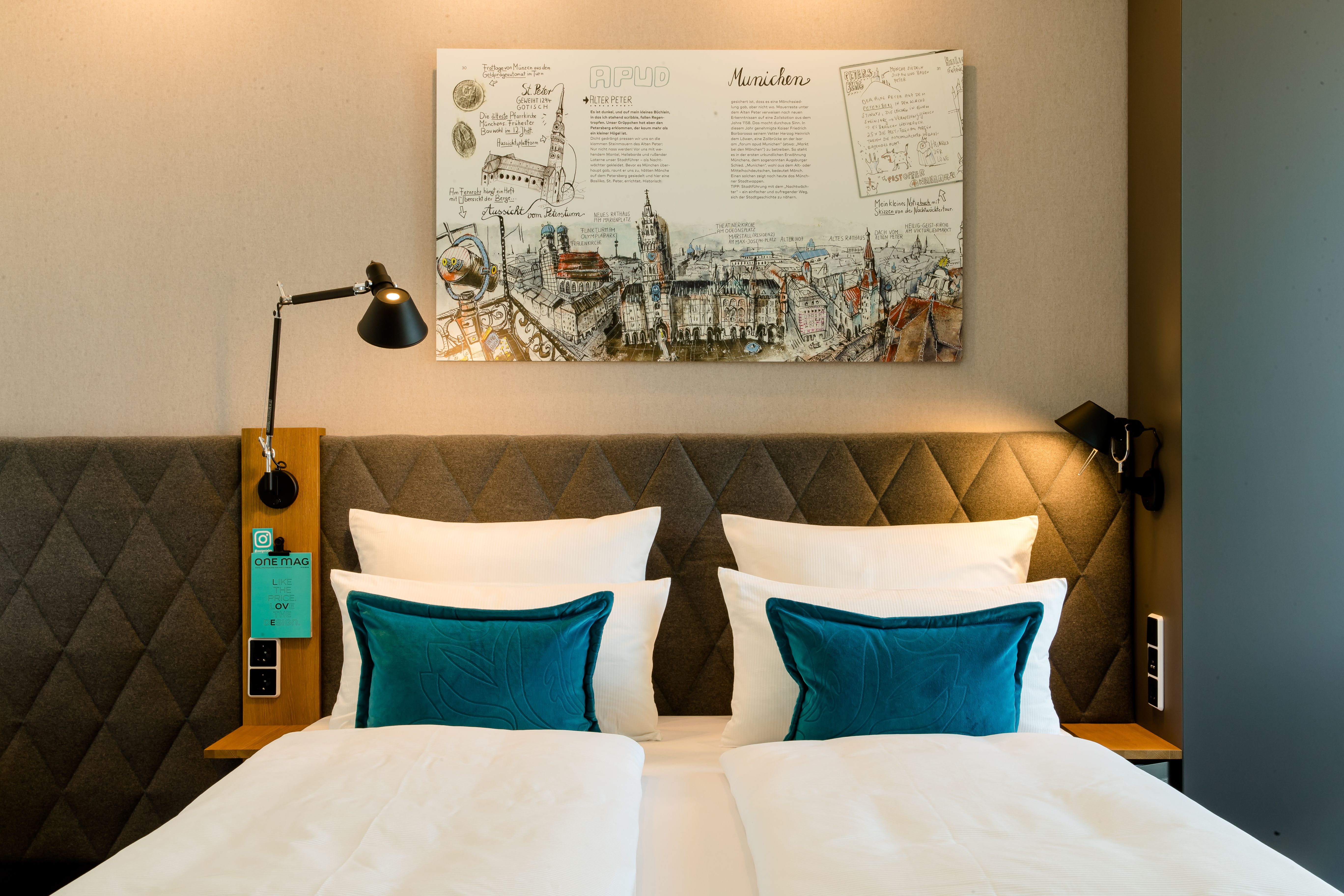 Hotel München Messe Motel One Zimmer Doppelbett mit Zierkissen und Bild über dem Bett