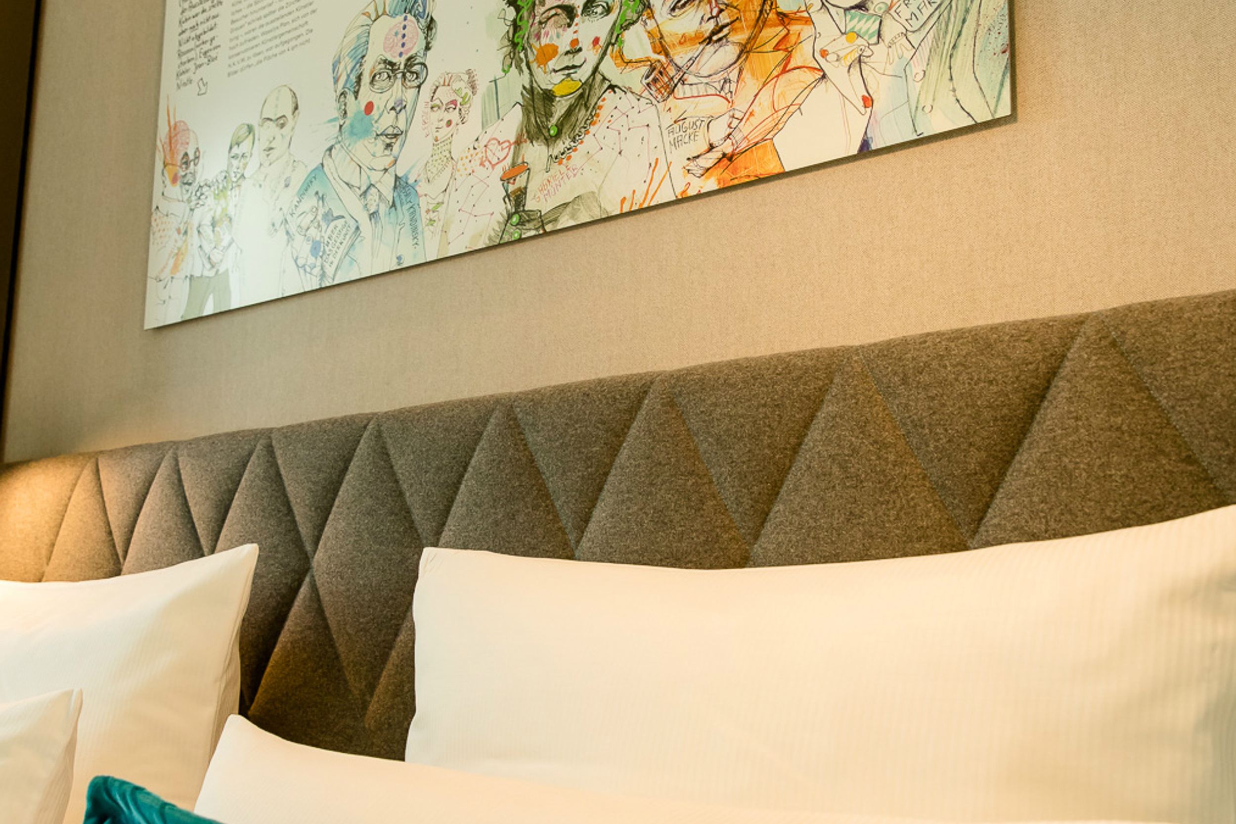 Designhotel München Messe Motel One Blick auf Kopfteil eines Doppelbettes mit Zierkissen