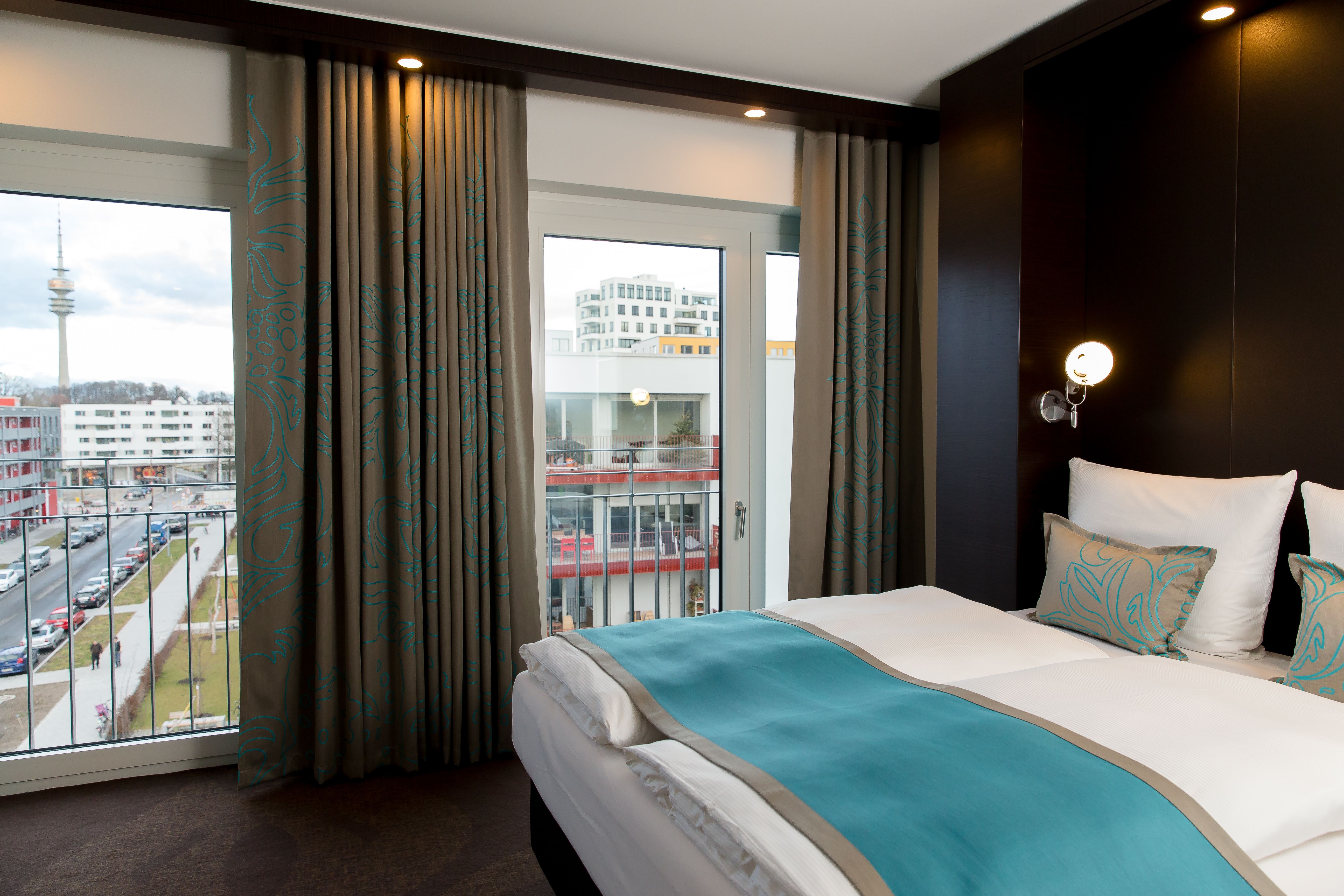 Hotel München Olympia Gate Motel One Zimmer mit Doppelbett und zwei bodentiefen Fenstern