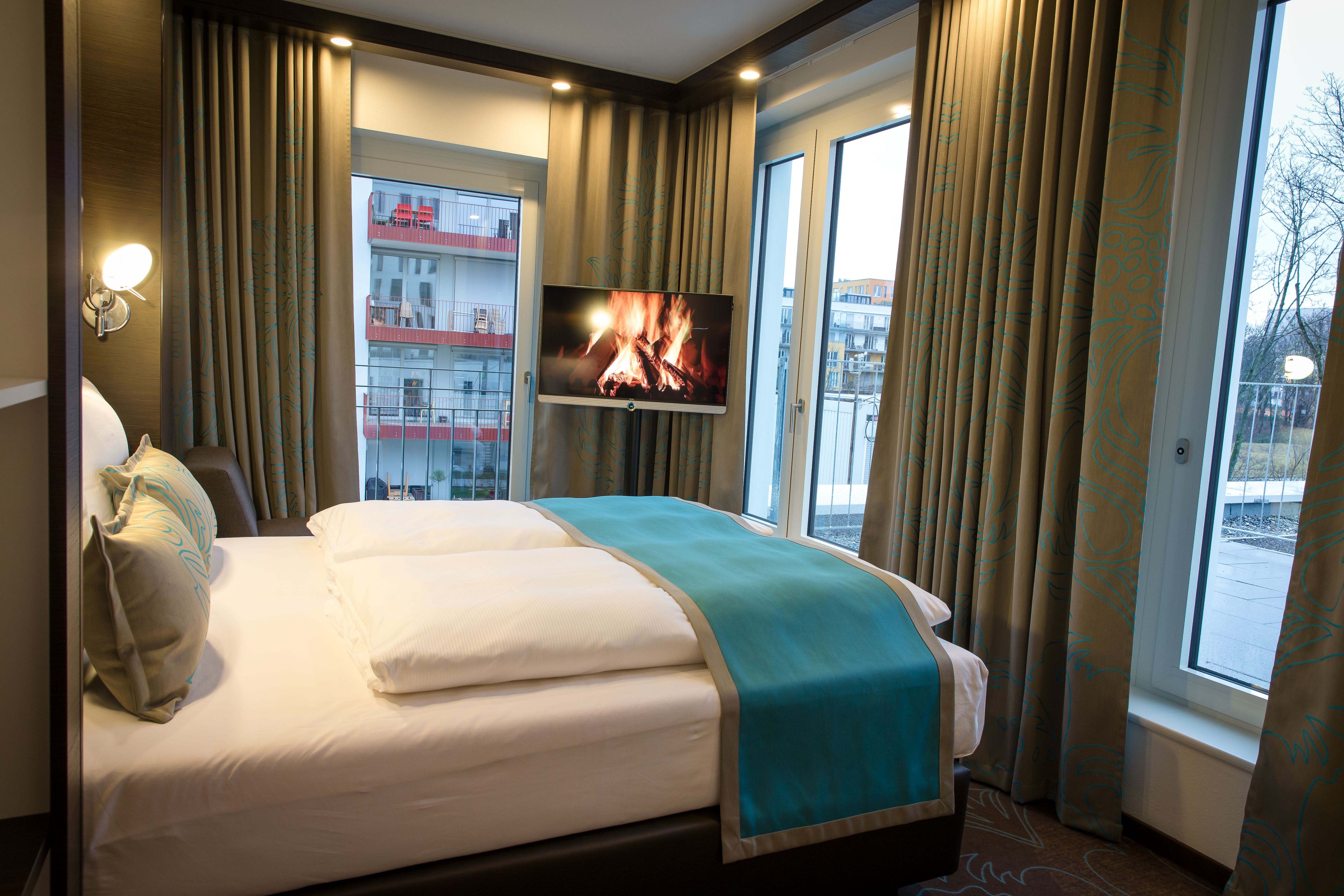 Designhotel München Olympia Gate Motel One Eckzimmer mit Doppelbett und TV
