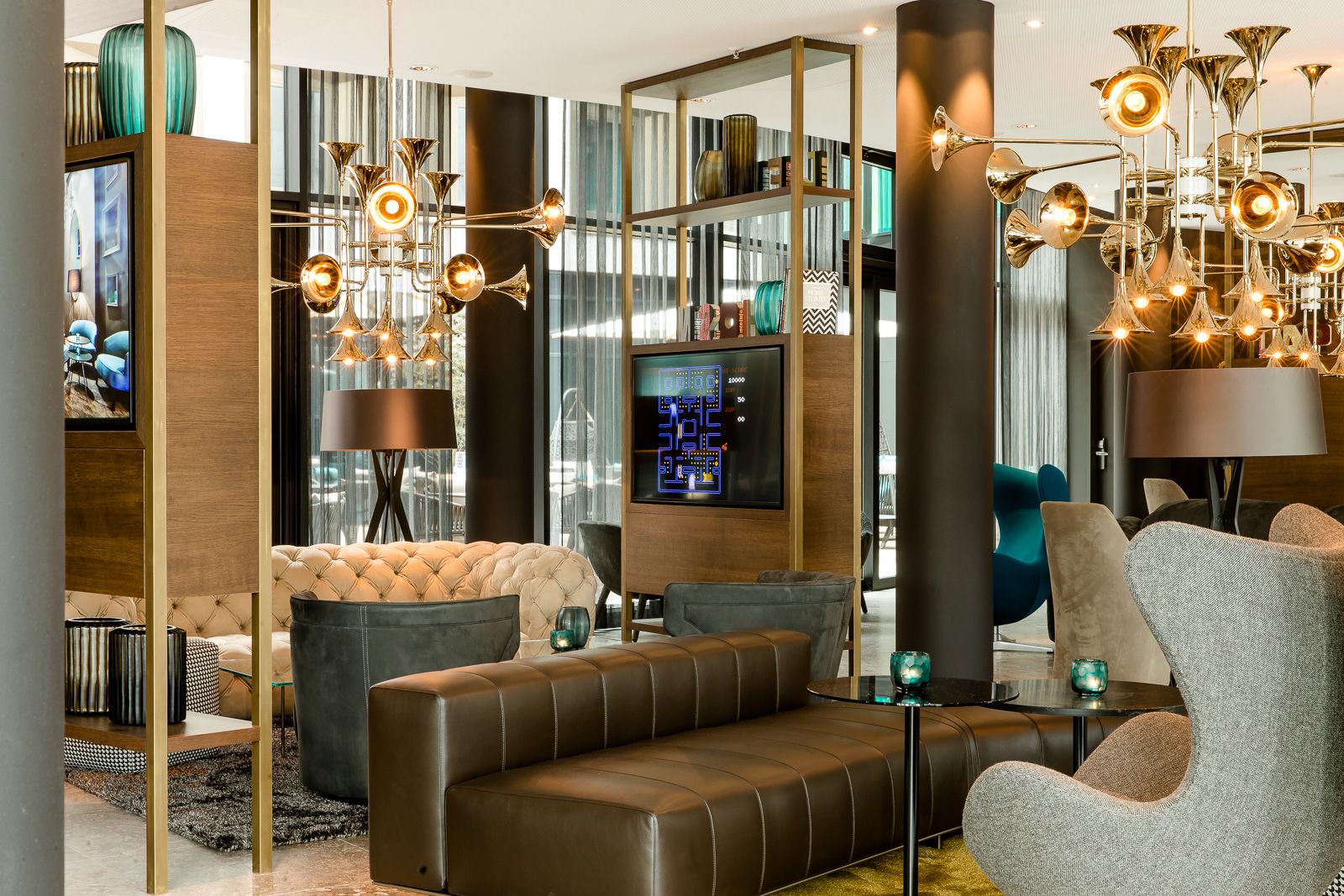 Hotels München Parkstadt Schwabing Motel One helle Lounge mit Sesseln, Couches und TV