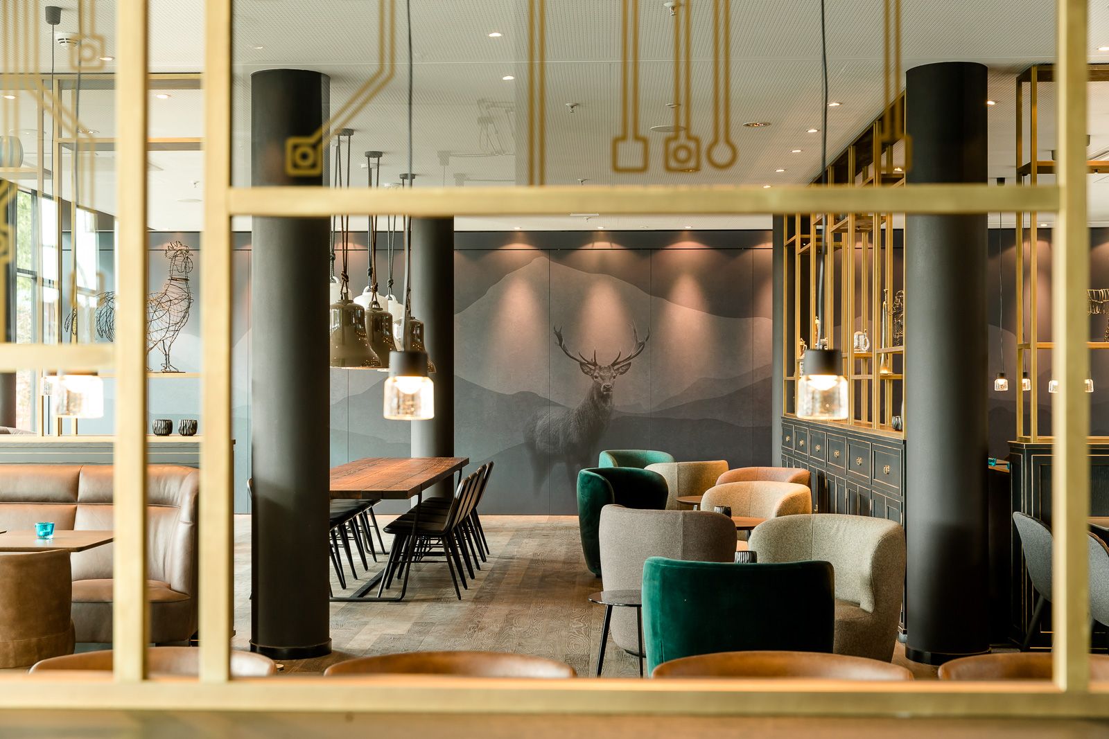 Hotel München Parkstadt Schwabing Motel One helle Lounge mit Sesseln sowie Tischen und Stühlen