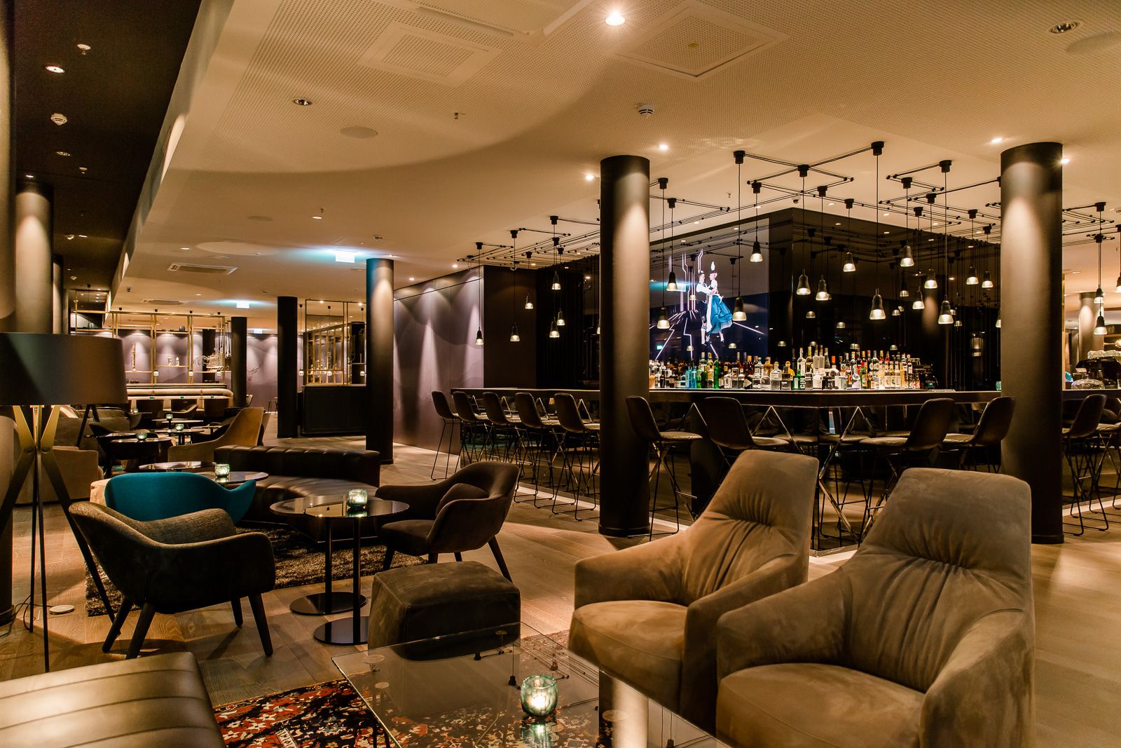 Designhotel München Parkstadt Schwabing Motel One große Lounge und Bar mit mehreren Sitzgelegenheiten bei Abend