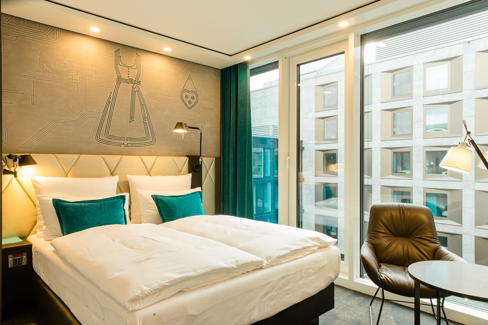 Hotel München Parkstadt Schwabing Motel One Zimmer mit bodentiefen Fenstern, Doppelbett sowie Tisch und Stuhl