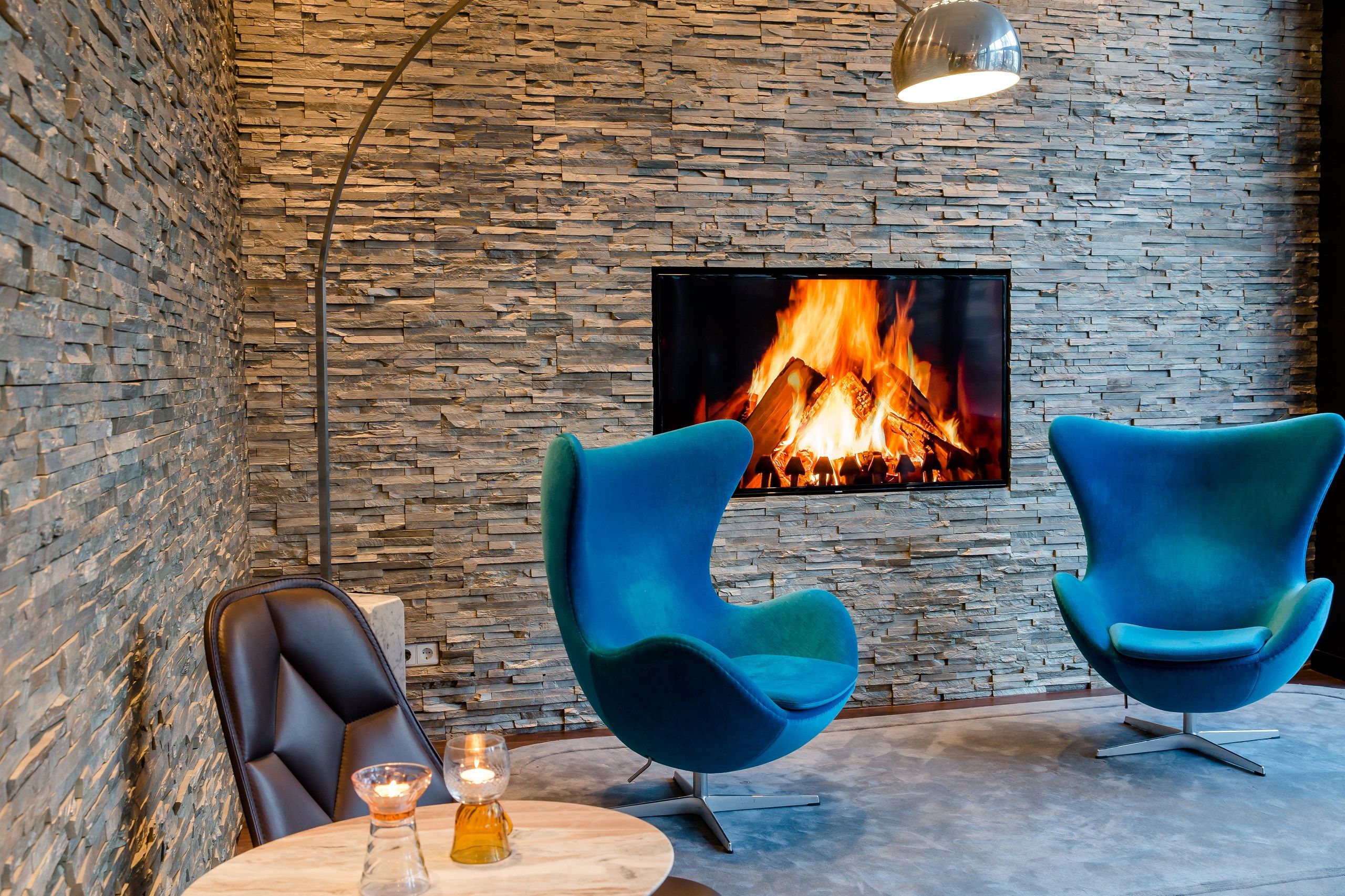 Hotel München Sendlinger Tor Motel One zwei Egg chairs vor TV mit Feuer