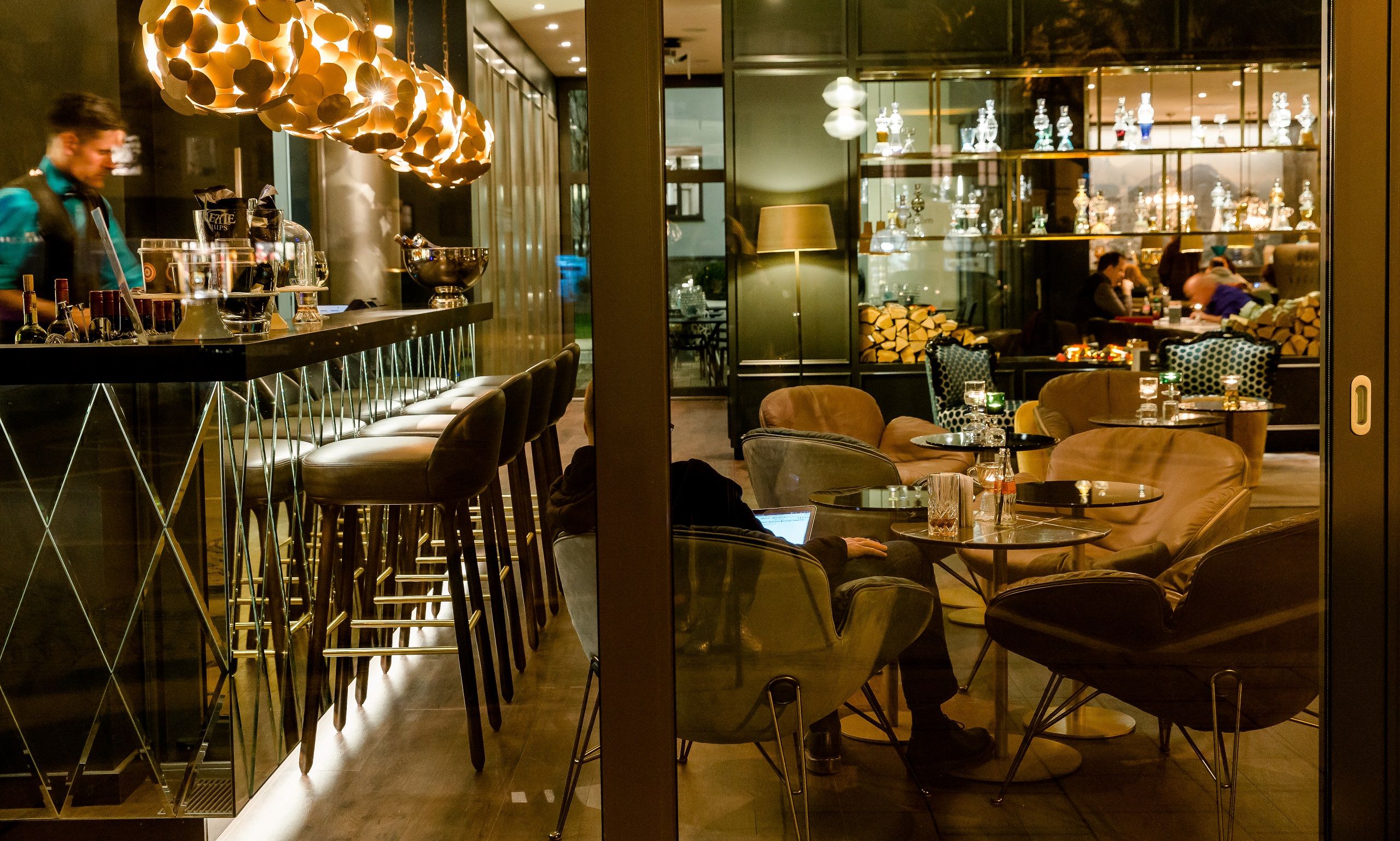 Hotel München Sendlinger Tor Motel One seitlicher Blick auf die Bar und Lounge mit Sesseln und Personen