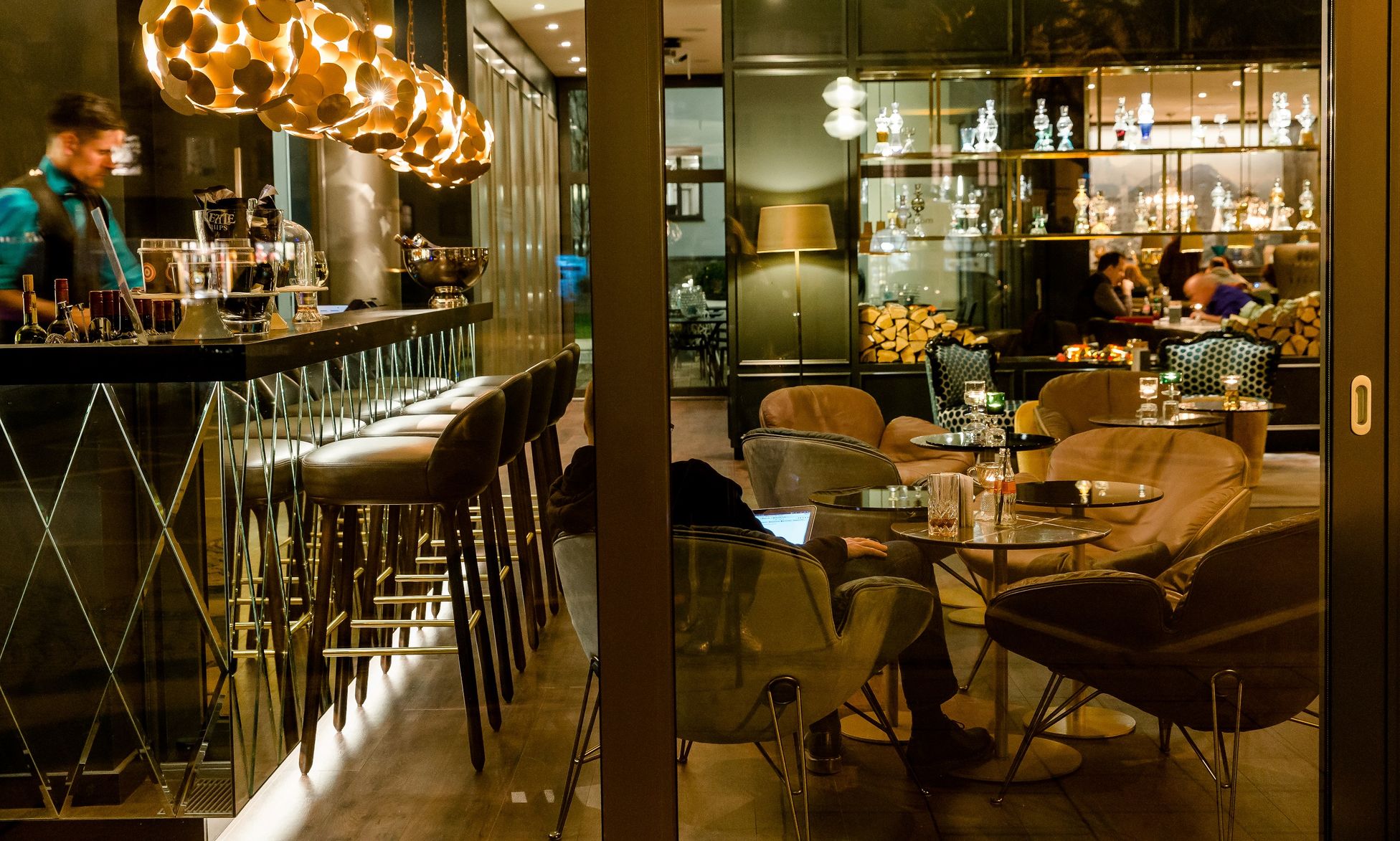 Hotel München Sendlinger Tor Motel One seitlicher Blick auf die Bar und Lounge mit Sesseln und Personen