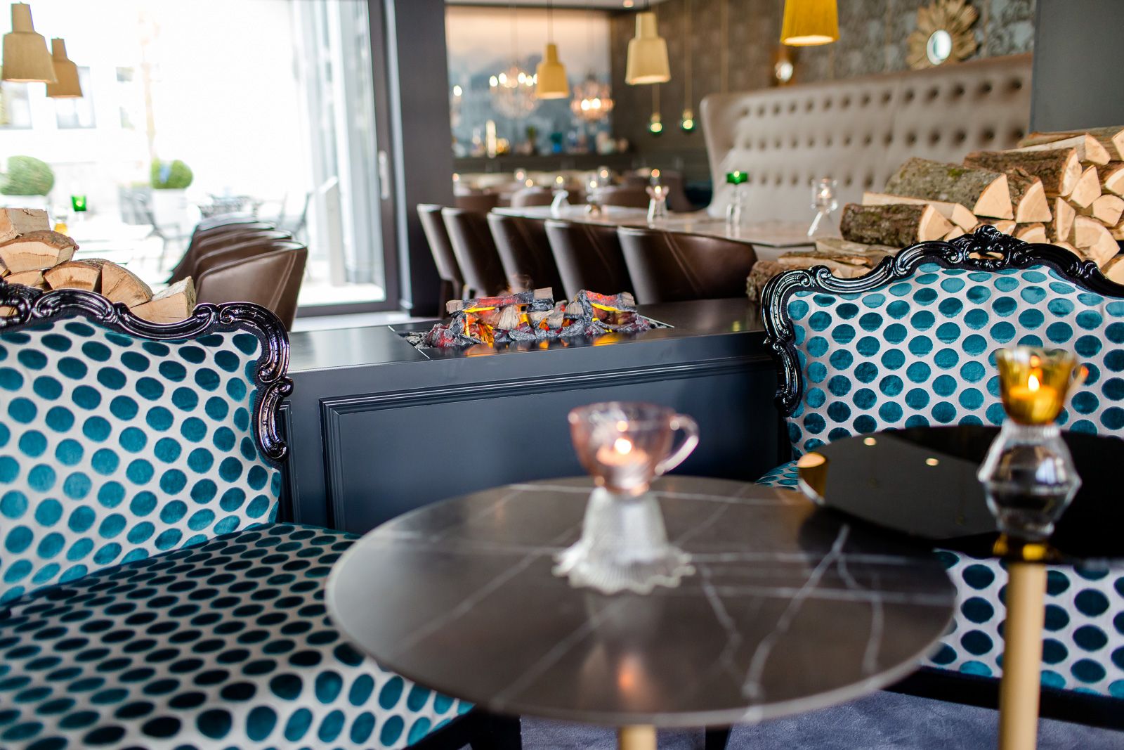 Hotel München Sendlinger Tor Motel One Sessel in heller Lounge und unechtes offenes Feuer als Dekoration