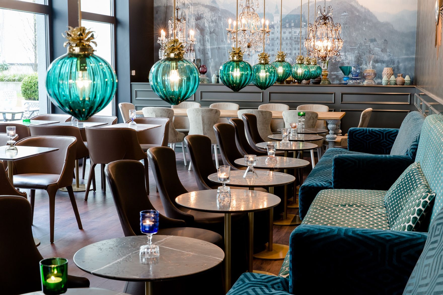 Hotel München Sendlinger Tor Motel One lichtdurchfluteter Bereich mit mehreren Tischen und Stühlen