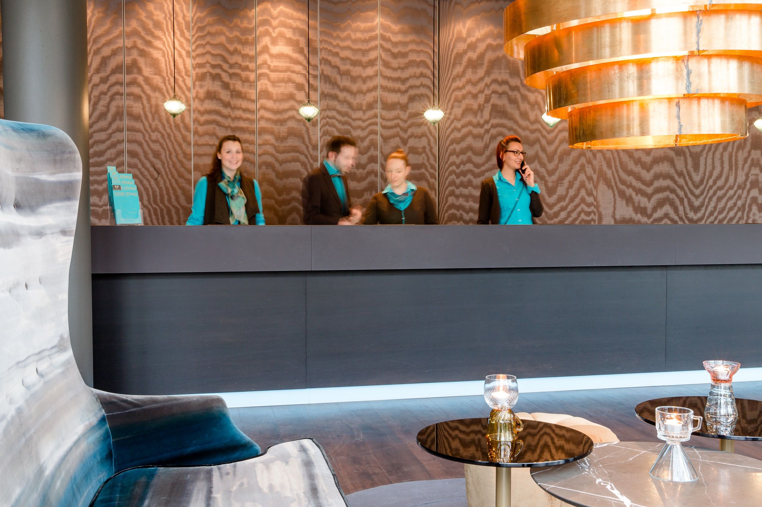 Hotel München Sendlinger Tor Motel One Rezeption mit vier Mitarbeitenden