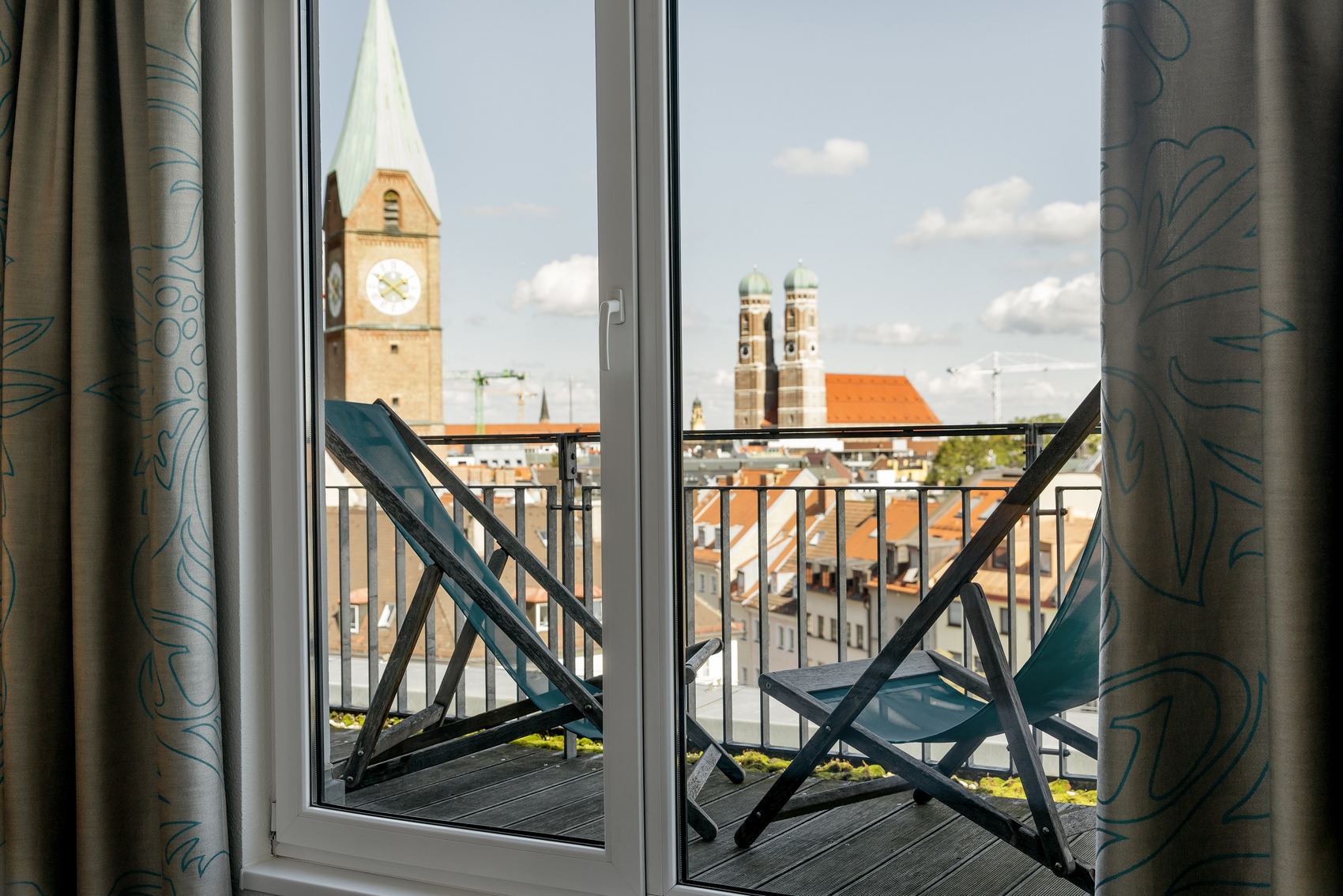 Designhotel München Sendlinger Tor Motel One Balkonzimmer mit zwei Liegestühlen und Aussicht über die Stadt