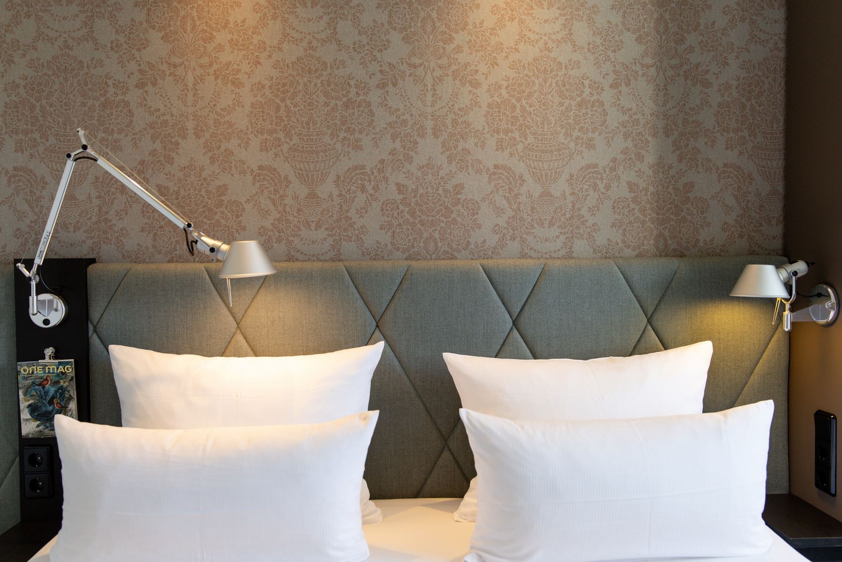 Hotel München Sendlinger Tor Motel One Blick auf Kopfteil eines Doppelbettes mit vier weißen Kissen