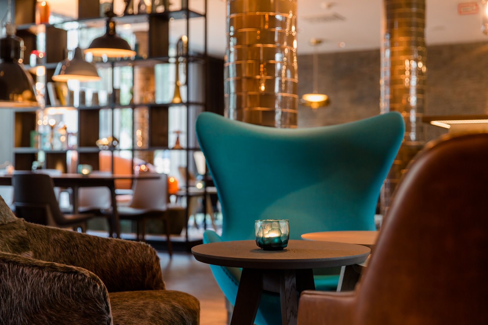 Hotel München Westend Motel One Nahaufnahme Egg Chair in heller Lounge mit mehreren Sesseln