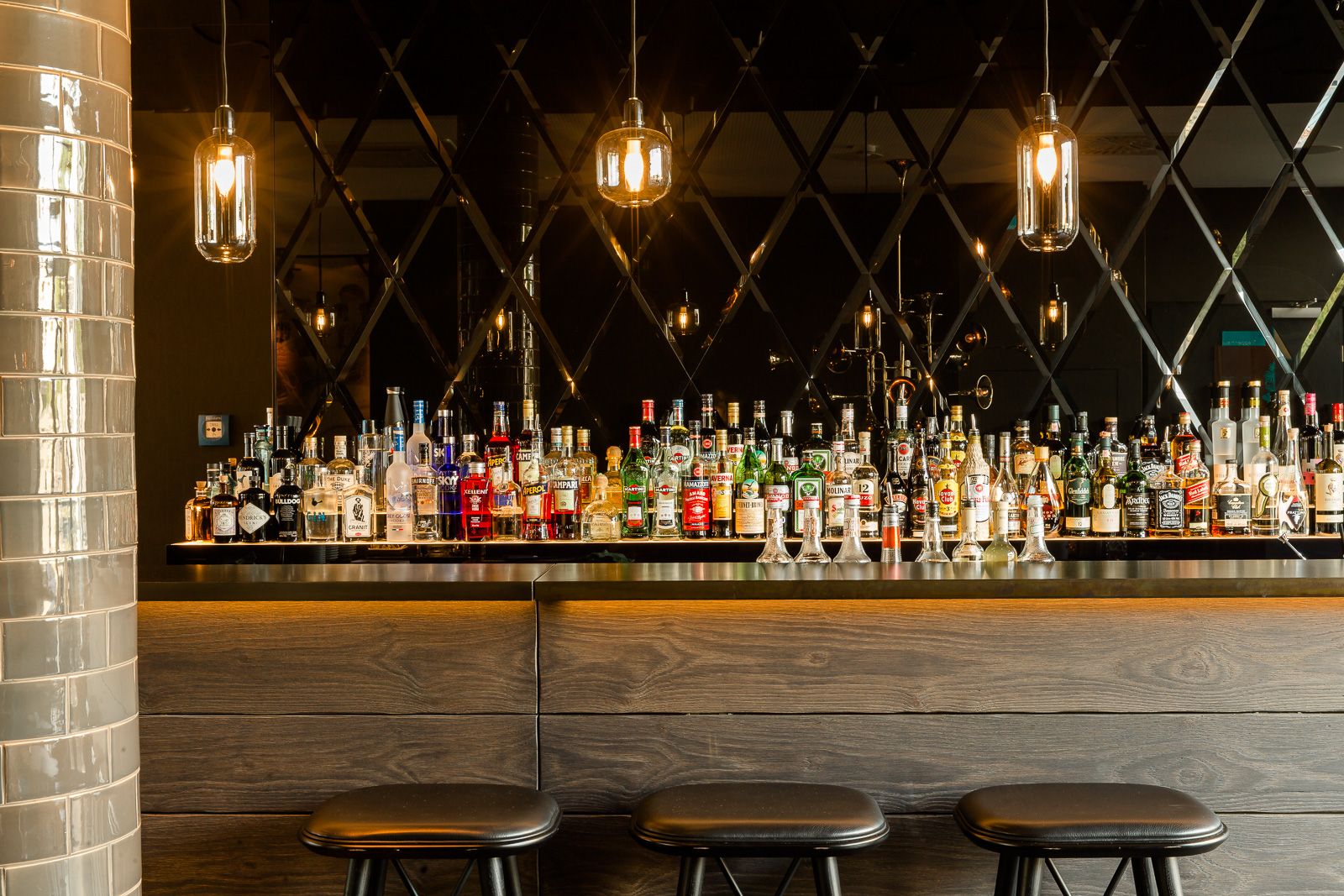 Hotel München Westend Motel One Bar mit mehreren Getränkeflaschen sowie Barhockern