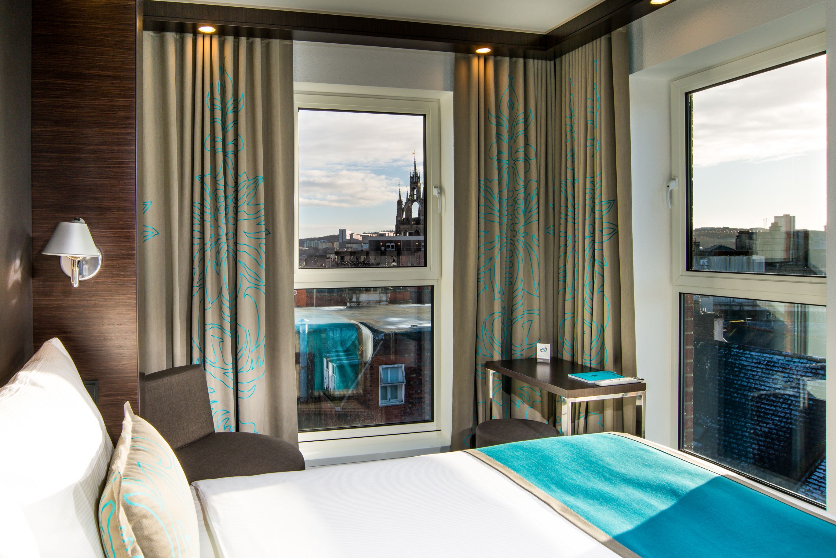 Designhotel Newcastle Motel One Eckzimmer mit Bett sowie Aussicht auf die Stadt