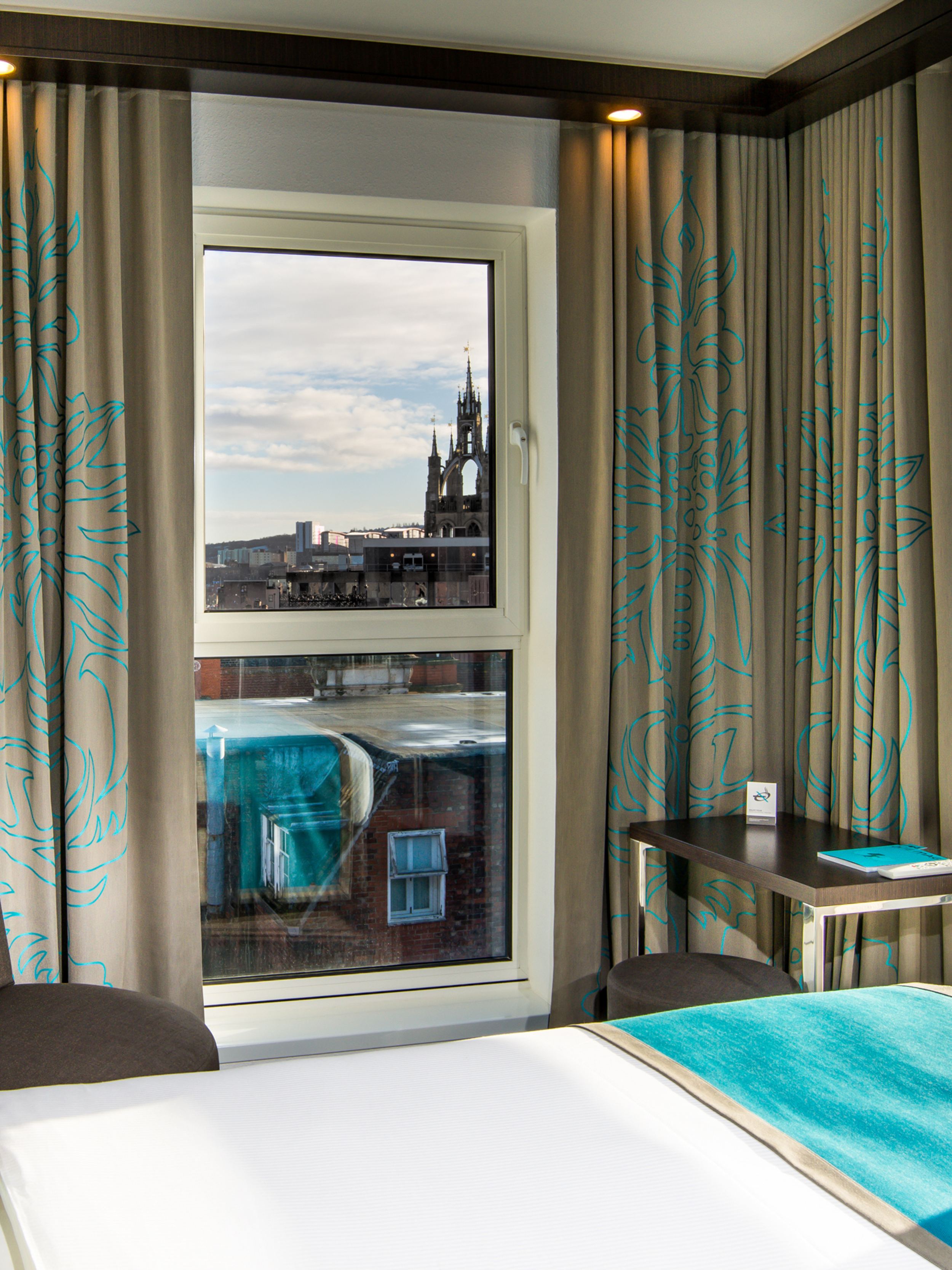 designhotel Newcastle Motel One corner room with bed and city view