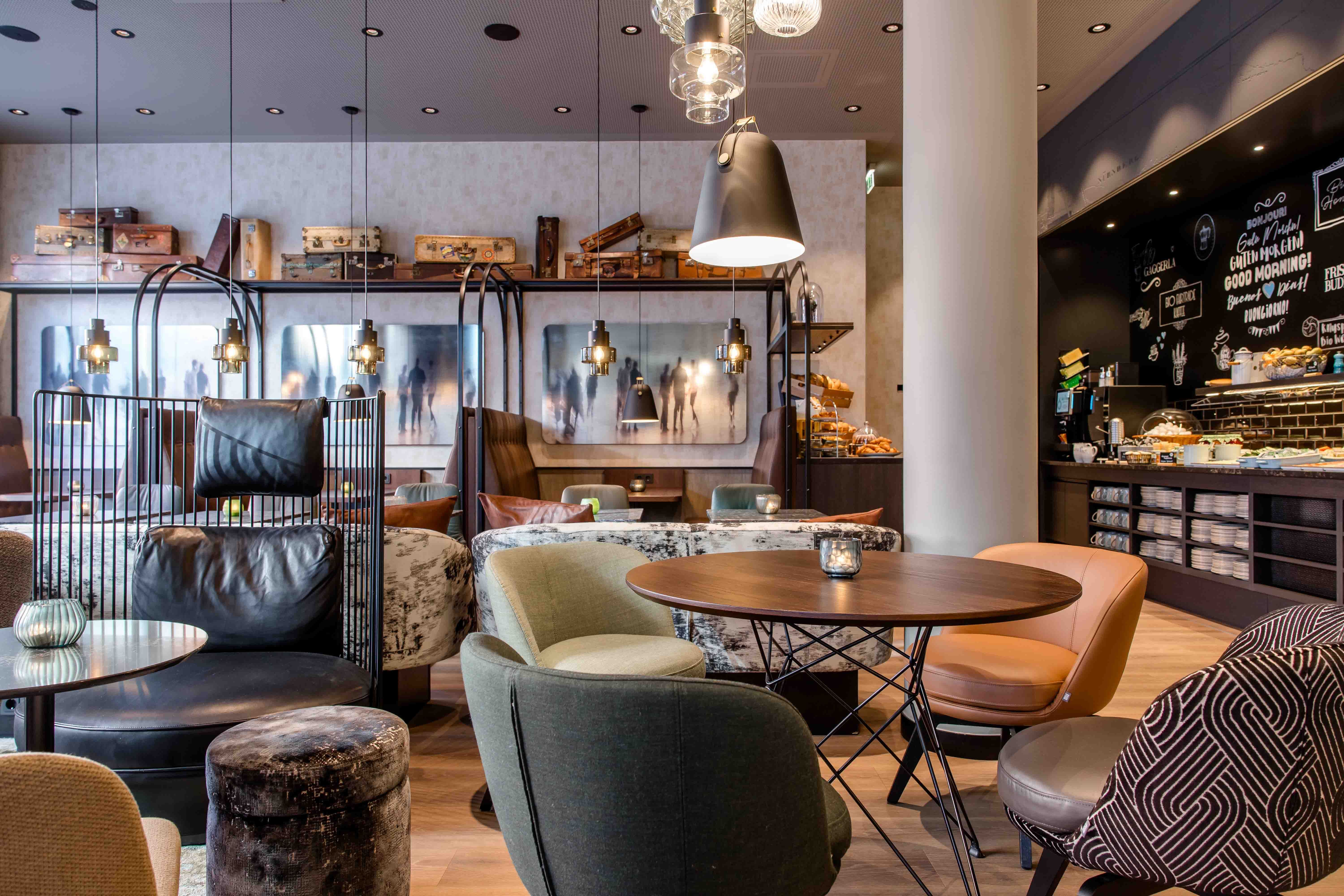 Designhotel Nürnberg City Motel One Frühstücksbuffet mit mehreren Tischen und Stühlen