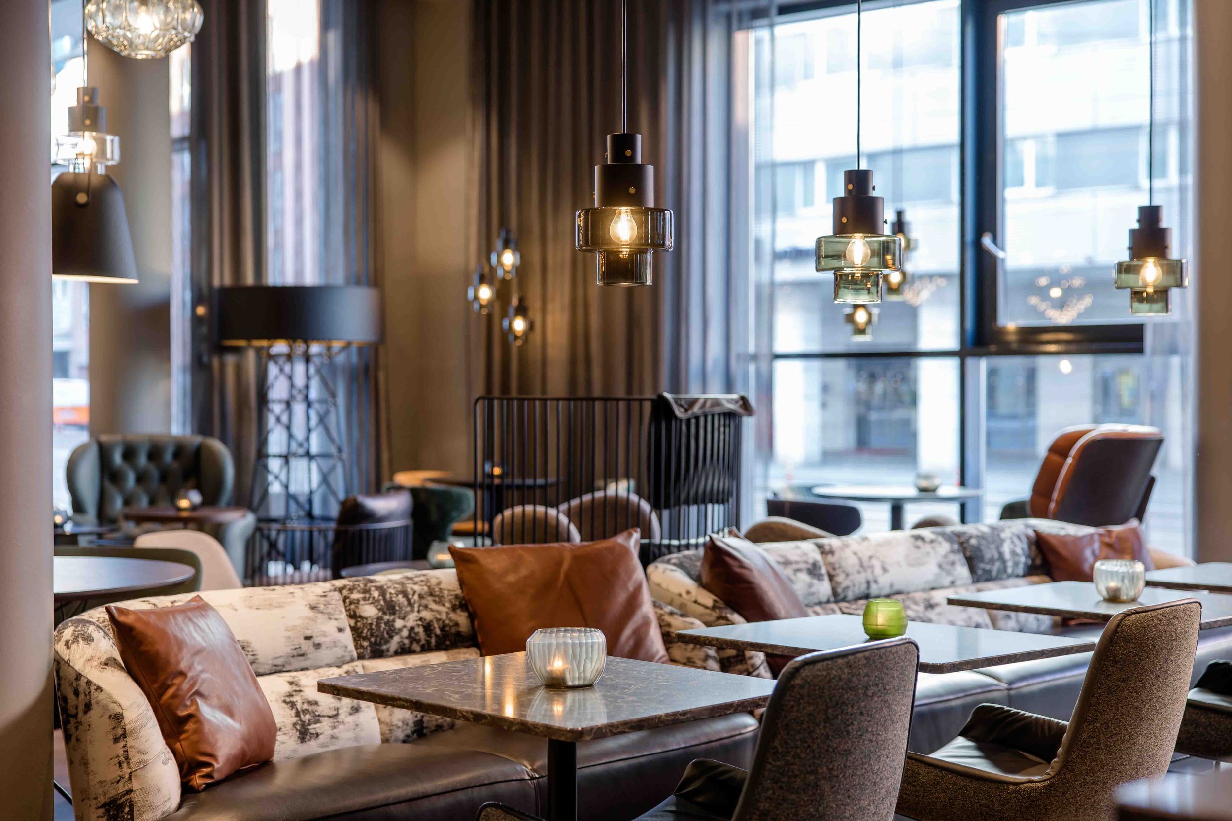 Designhotel Nürnberg City Motel One Lounge mit Tischen, Stühlen und Sesseln