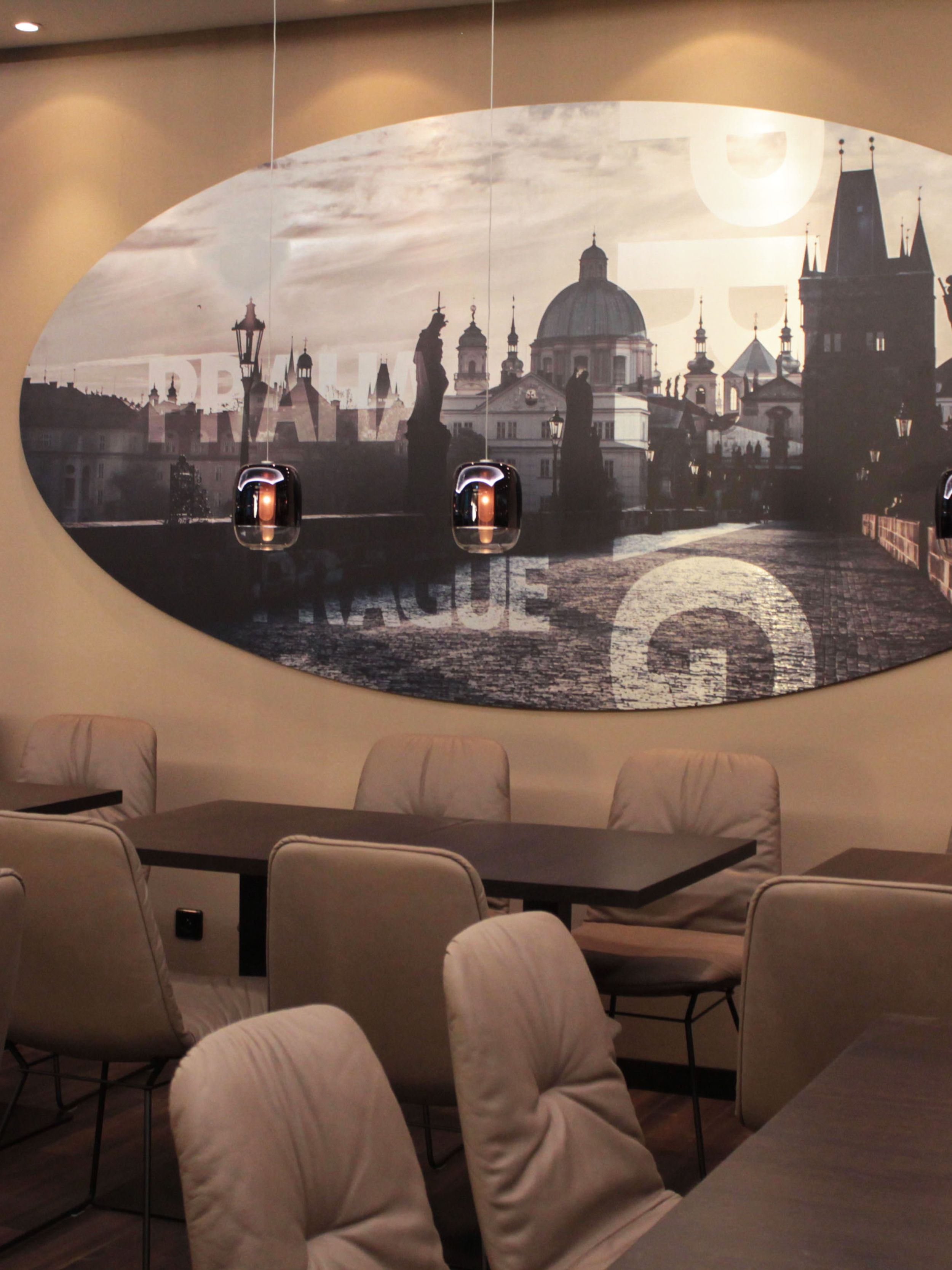 Hotel Prag Florentinum Motel One Tische und Stühle mit Stadtbild von Prag an der Wand