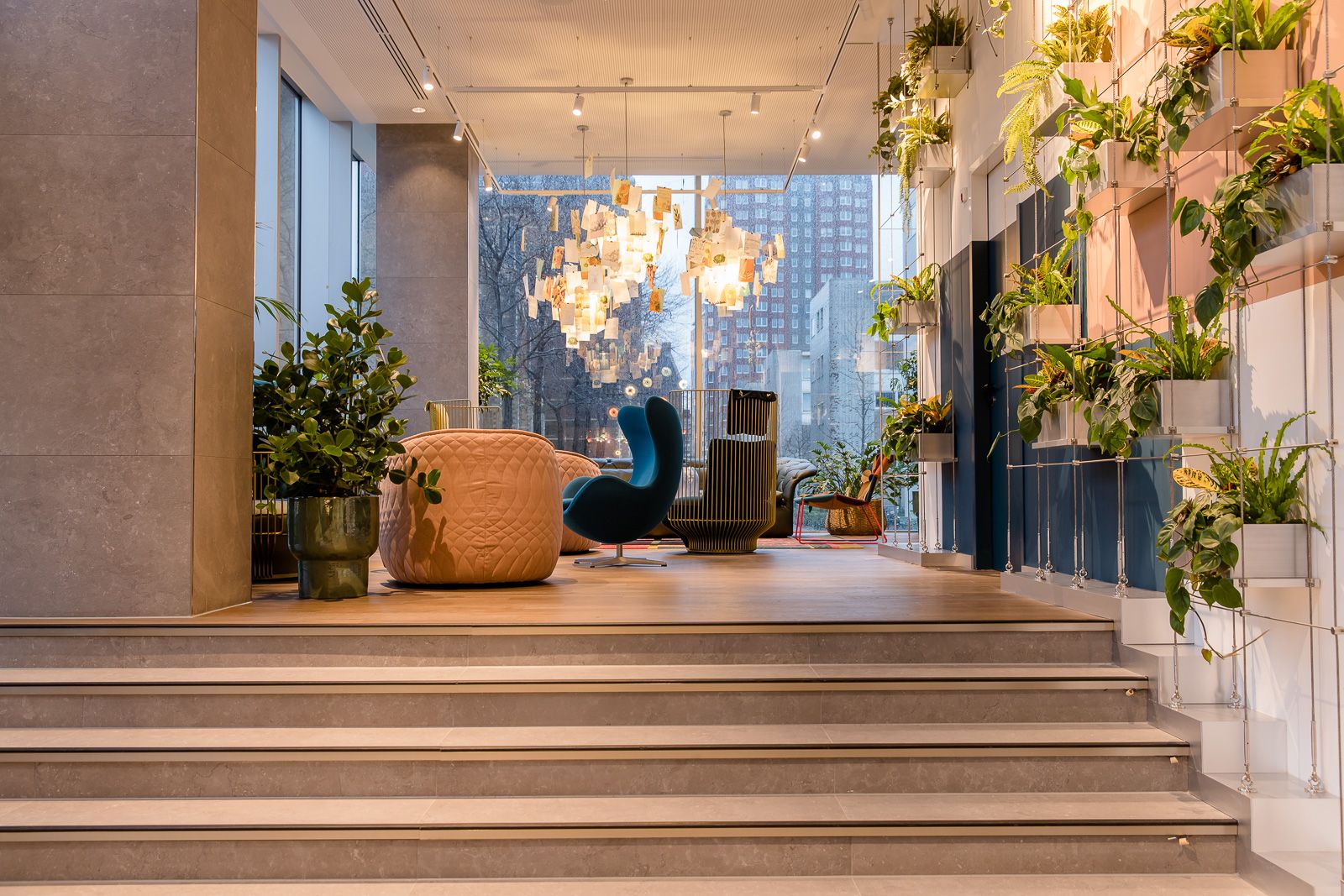 Designhotel Rotterdam Motel One lichtdurchfluteter Eingangsbereich mit Treppenstufen und Sitzgelegenheiten