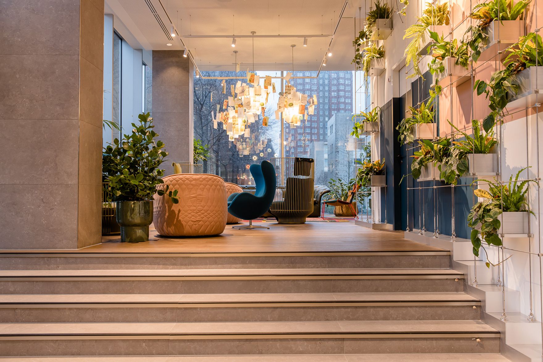 Designhotel Rotterdam Motel One lichtdurchfluteter Eingangsbereich mit Treppenstufen und Sitzgelegenheiten
