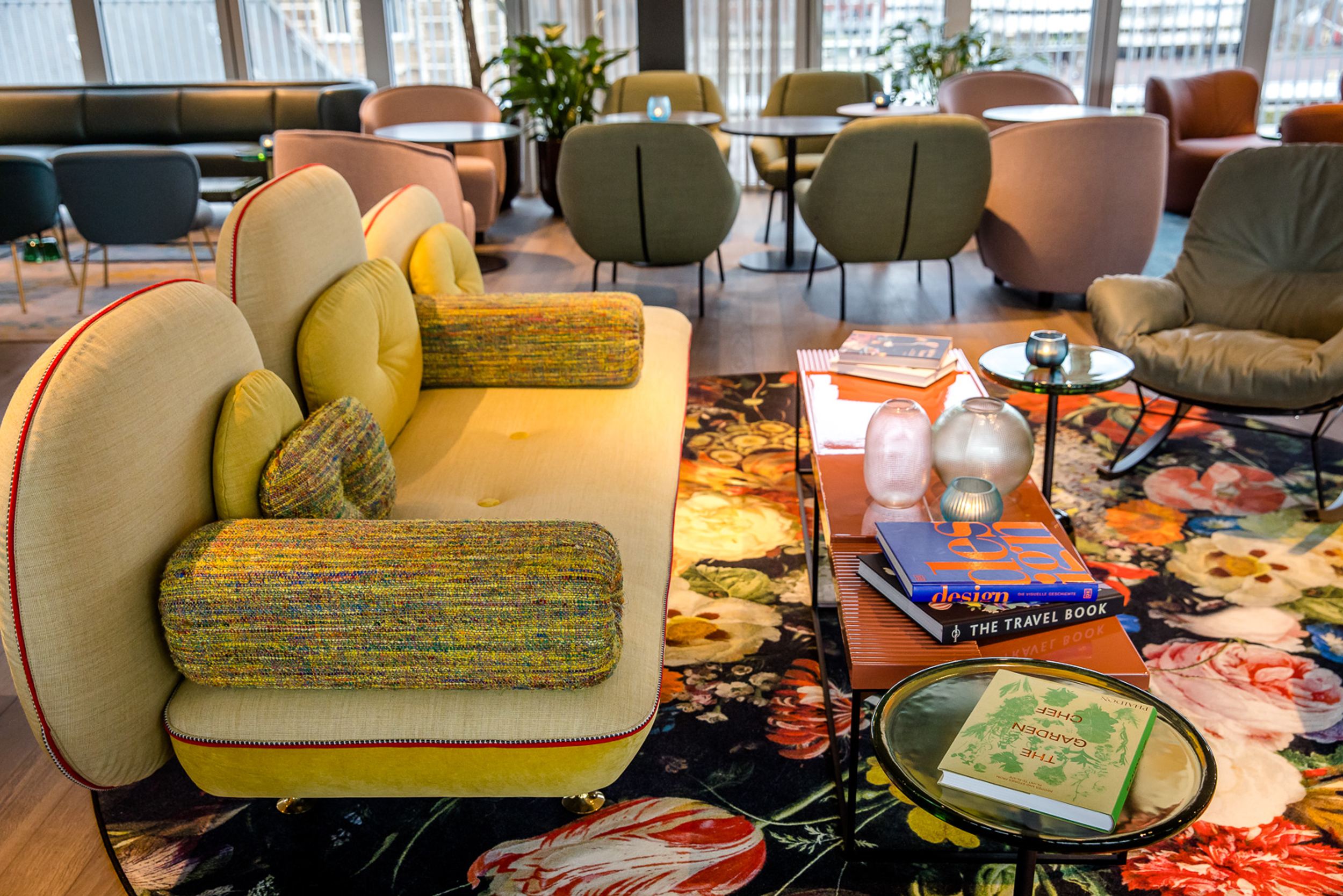 Designhotel Rotterdam Motel One Lounge mit Couch sowie langem Tisch mit Stühlen