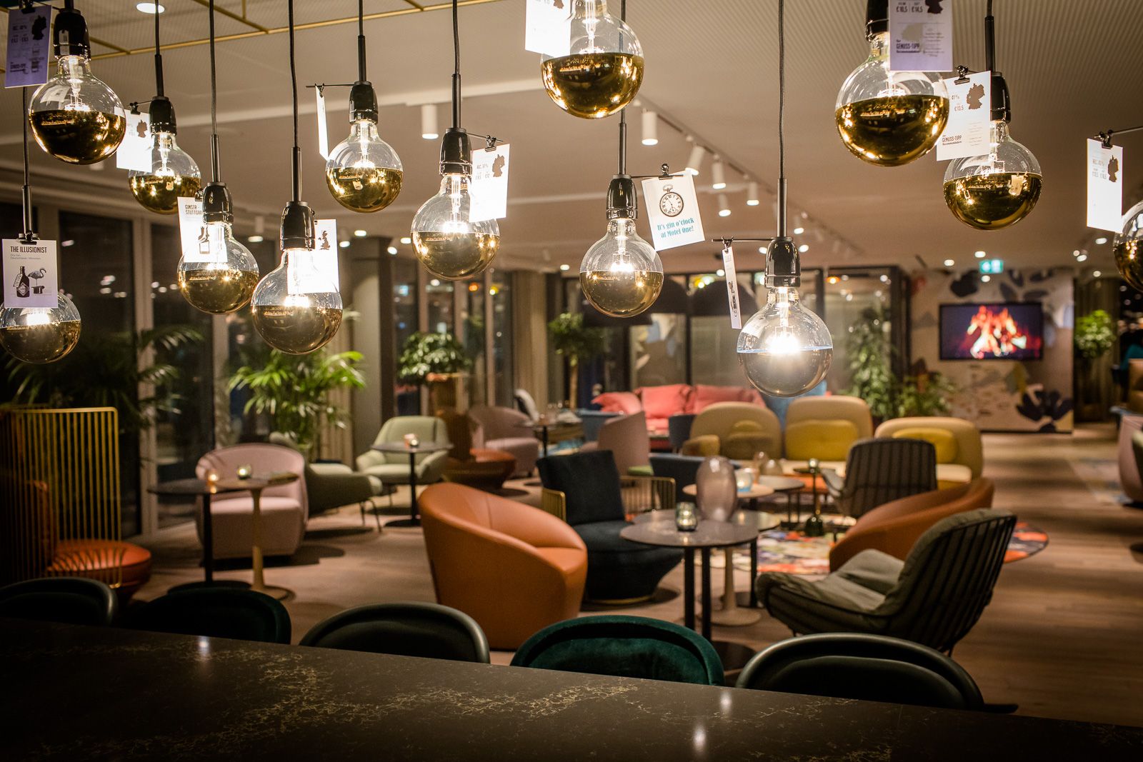 Designhotel Rotterdam Motel One Lounge bei Abend und mehrere Deckenlampen