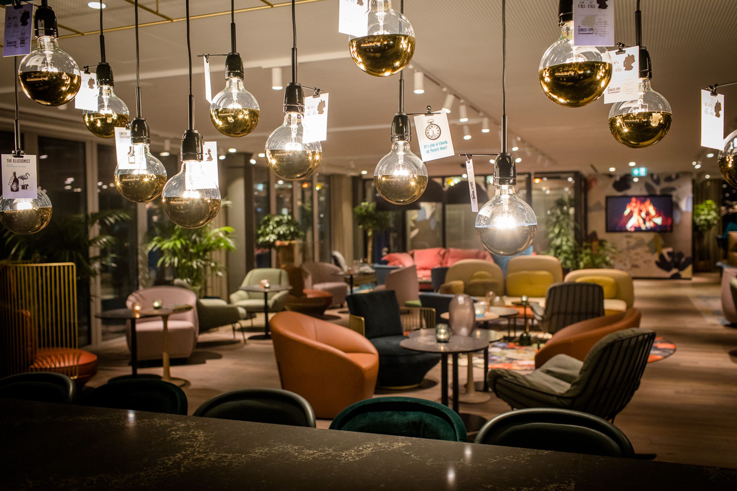 Designhotel Rotterdam Motel One Lounge bei Abend und mehrere Deckenlampen