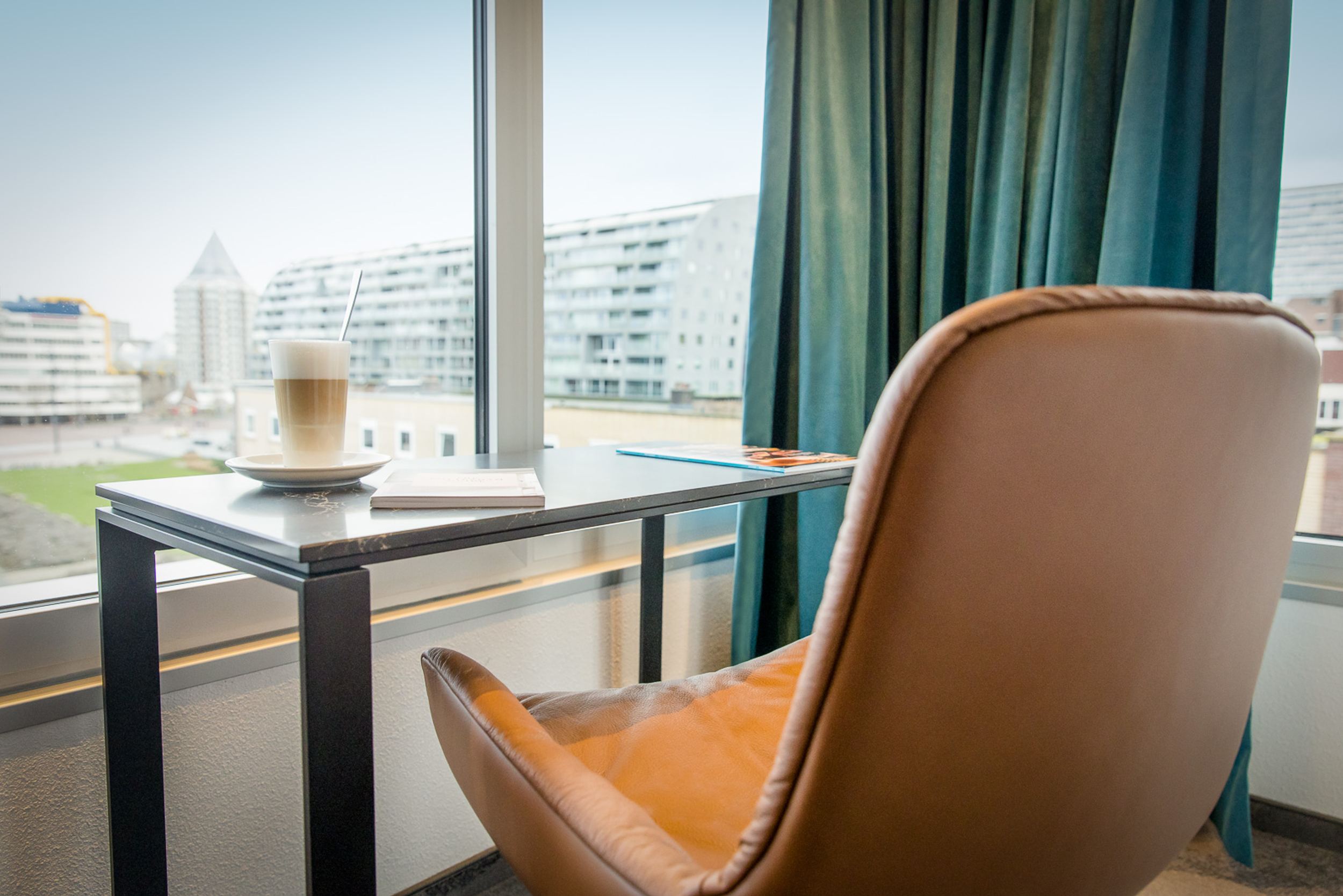 Hotel Rotterdam Motel One Zimmer mit Schreibtisch und Stuhl vor großem Fenster mit Aussicht