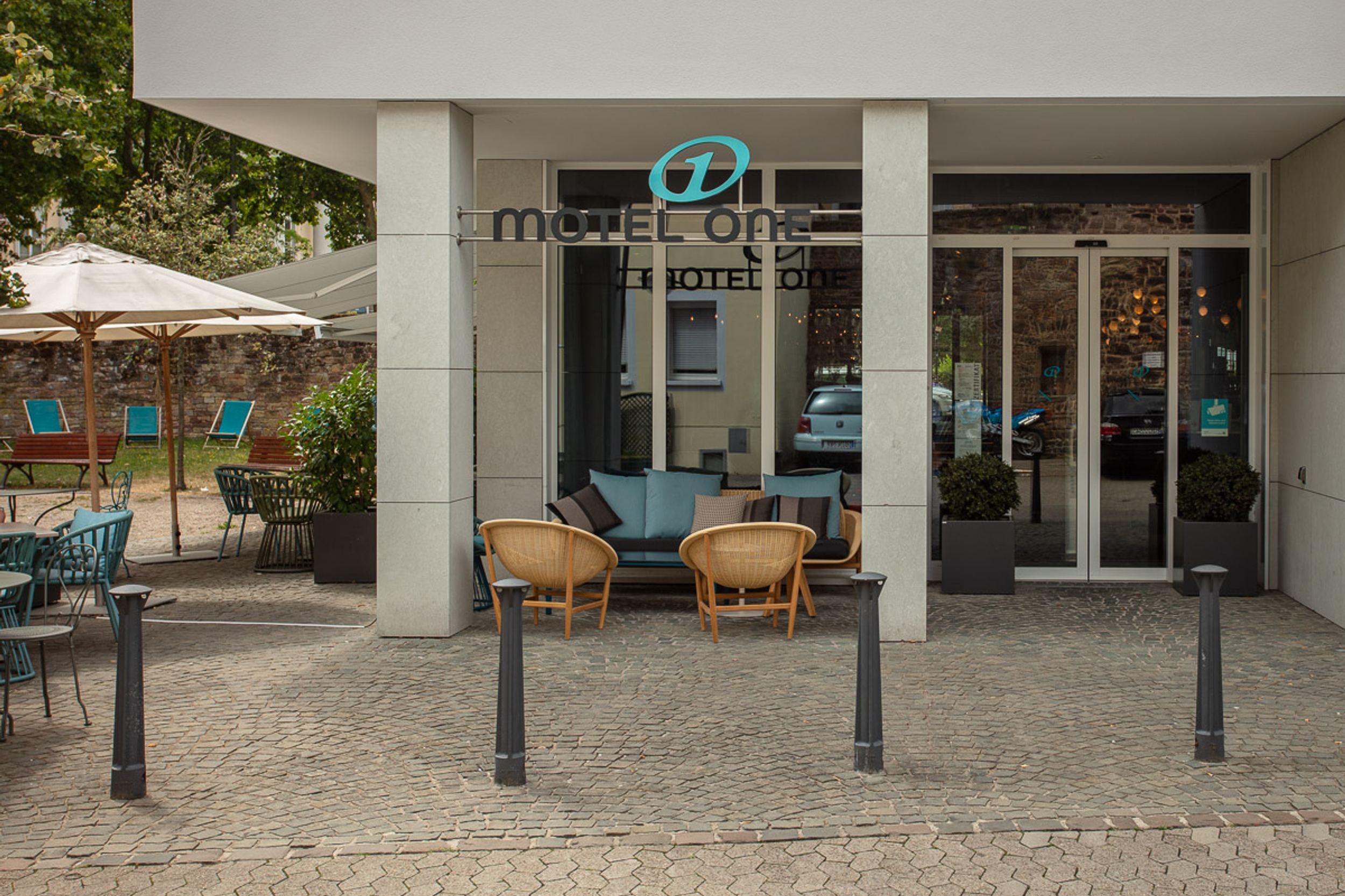 hotel Saarbrücken Motel One entrance area with logo and seating