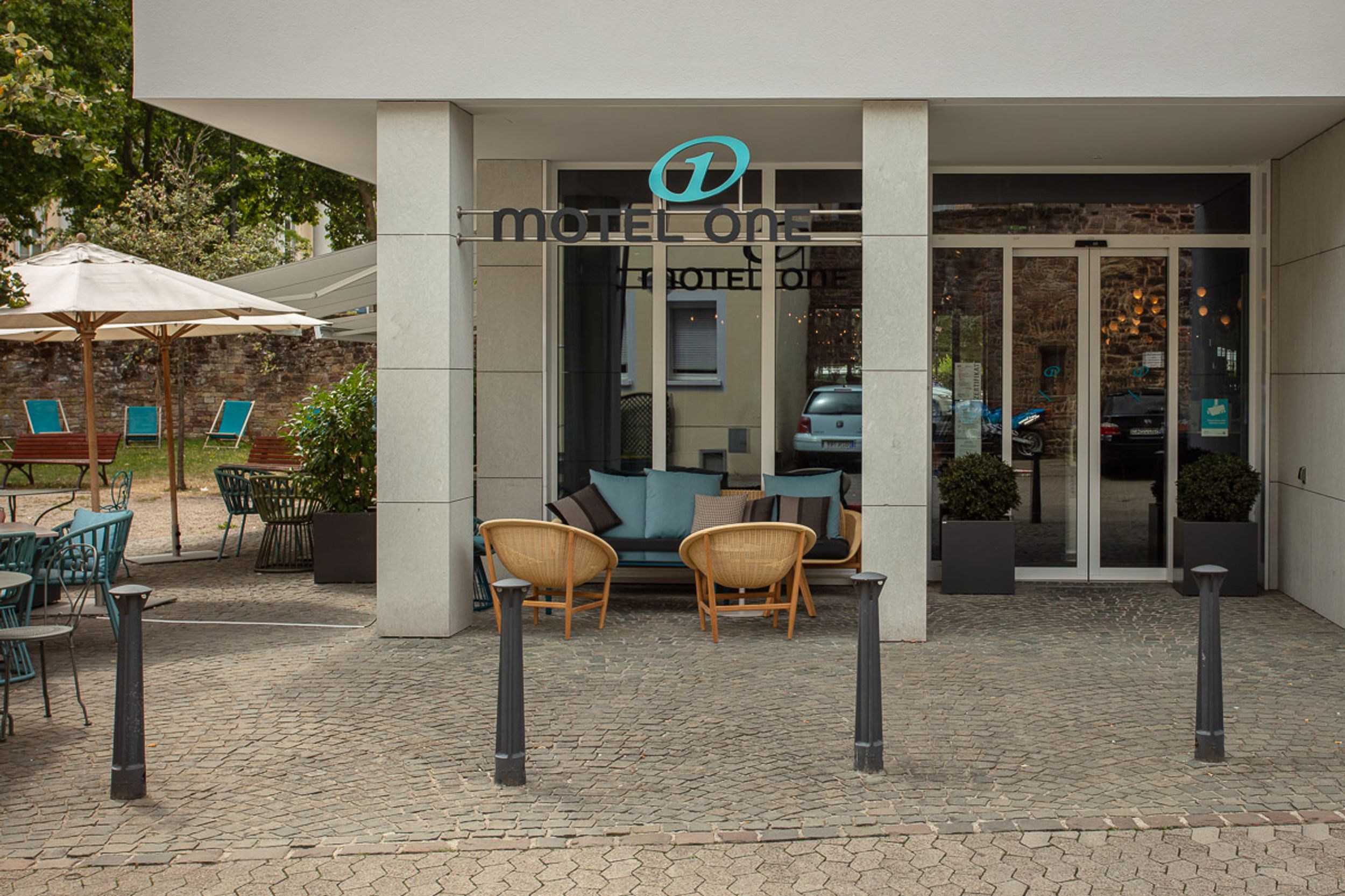Hotel Saarbrücken Motel One Eingangsbereich mit Logo und Sitzgelegenheiten