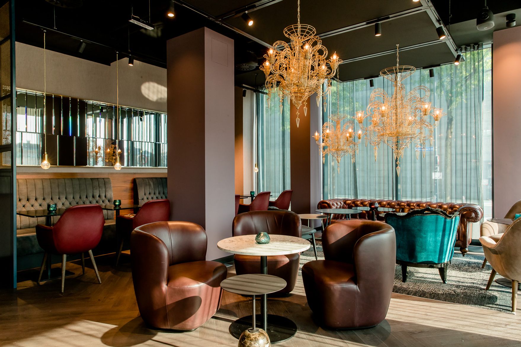 Designhotel Salzburg Mirabell Motel One Lounge mit mehreren Sitzgelegenheiten und Tischen