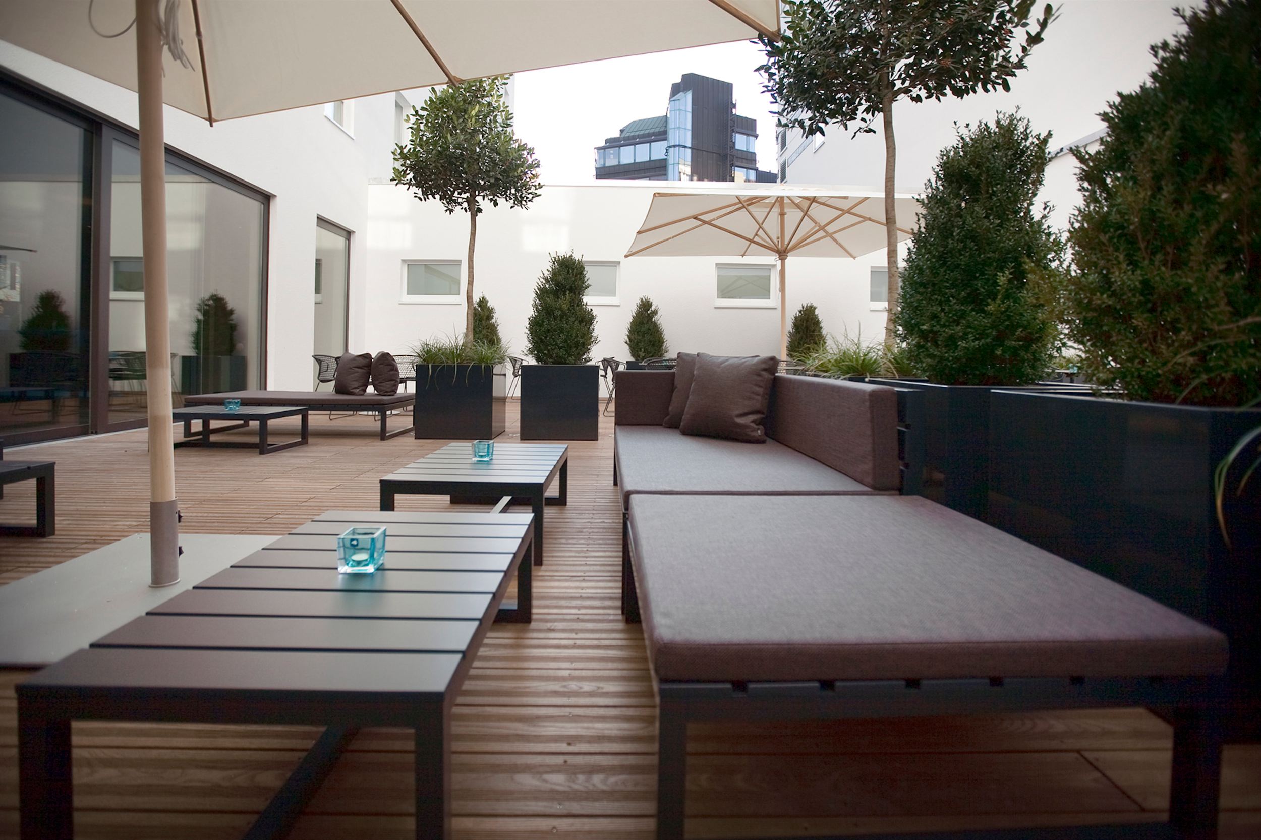 Hotel Stuttgart Mitte Motel One Terrasse mit Sitzgelegenheiten und Sonnenschirm