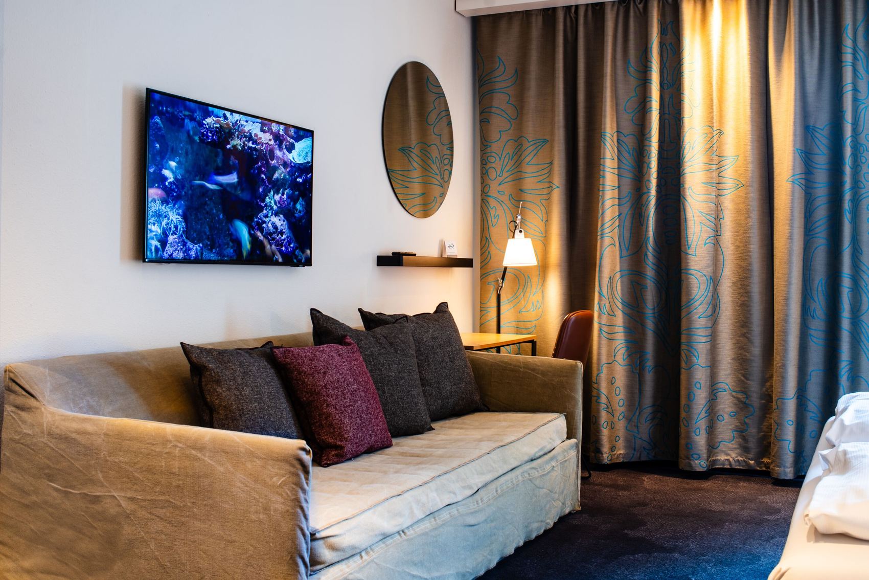 Hotel Stuttgart Mitte Motel One seitlicher Blick auf große Couch sowie Tisch und Stuhl