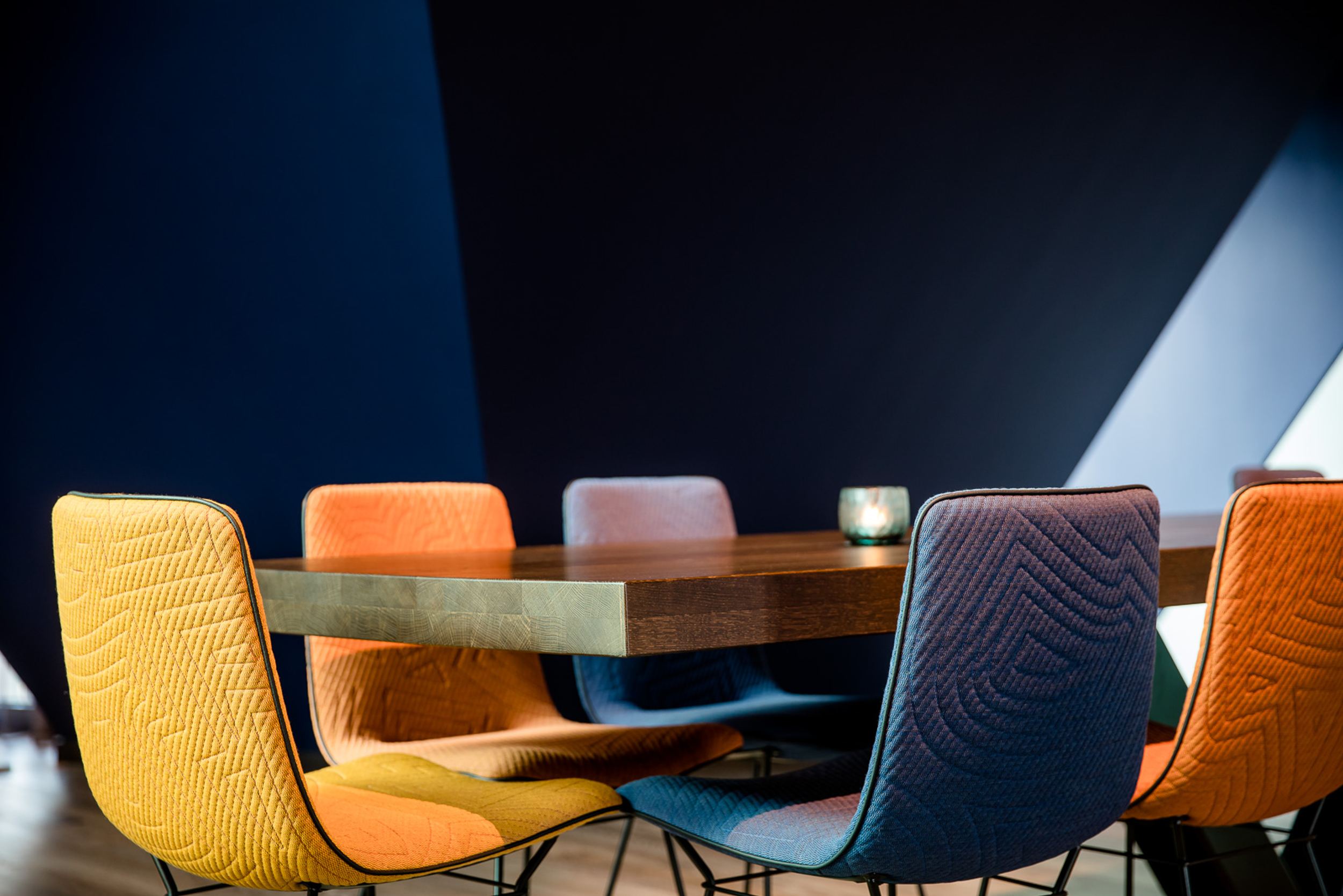 Hotel Ulm Motel One Tisch mit farbigen Stühlen