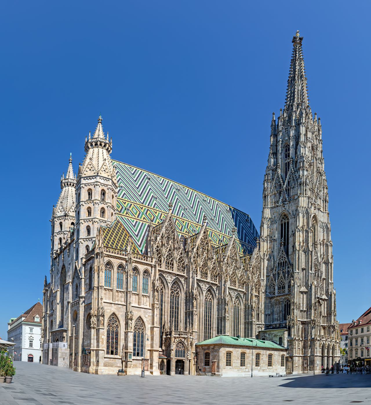 Gotischer Stephansdom in Wien mit farbigem Ziendach und hohem Turm unter klarem blauem Himmel. Gotischer Stephansdom in Wien mit farbigem Ziendach und hohem Turm unter klarem blauem Himmel.