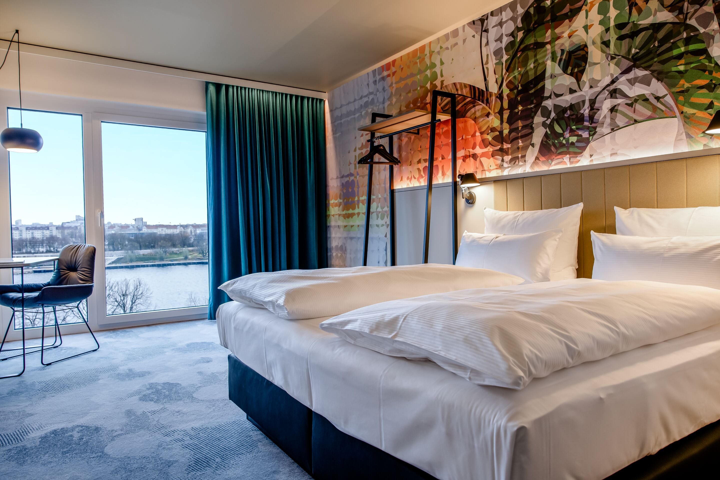 Hotel Wien Donau City Motel One seitlicher Blick in geräumiges Zimmer mit Doppelbett und Blick auf die Donau Hotel Wien Donau City Motel One seitlicher Blick in geräumiges Zimmer mit Doppelbett und Blick auf die Donau