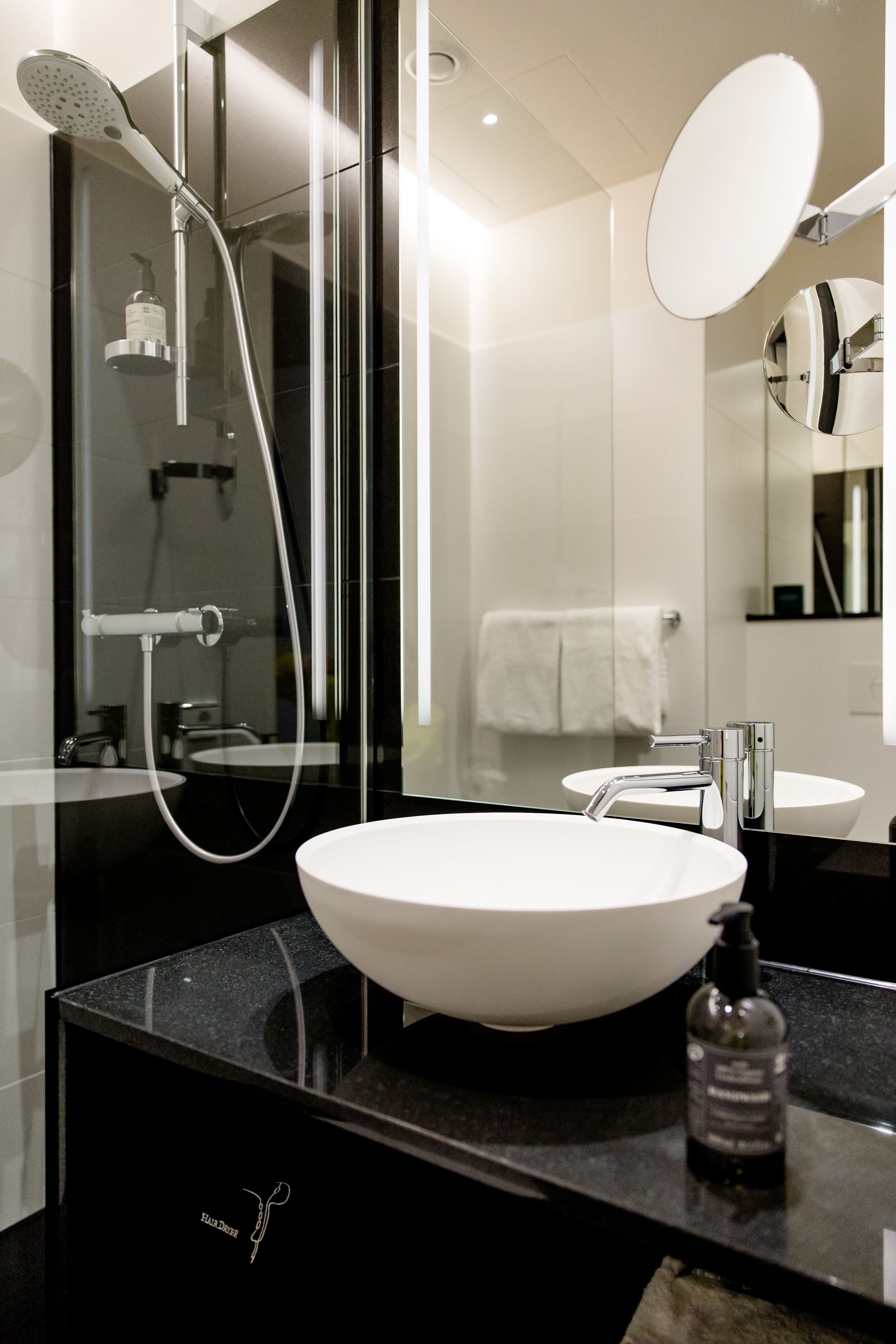 Hotel Wien Donau City Motel One Bad mit Blick auf die Dusche, ein Waschbecken sowie einen großen Spiegel Hotel Wien Donau City Motel One Bad mit Blick auf die Dusche, ein Waschbecken sowie einen großen Spiegel