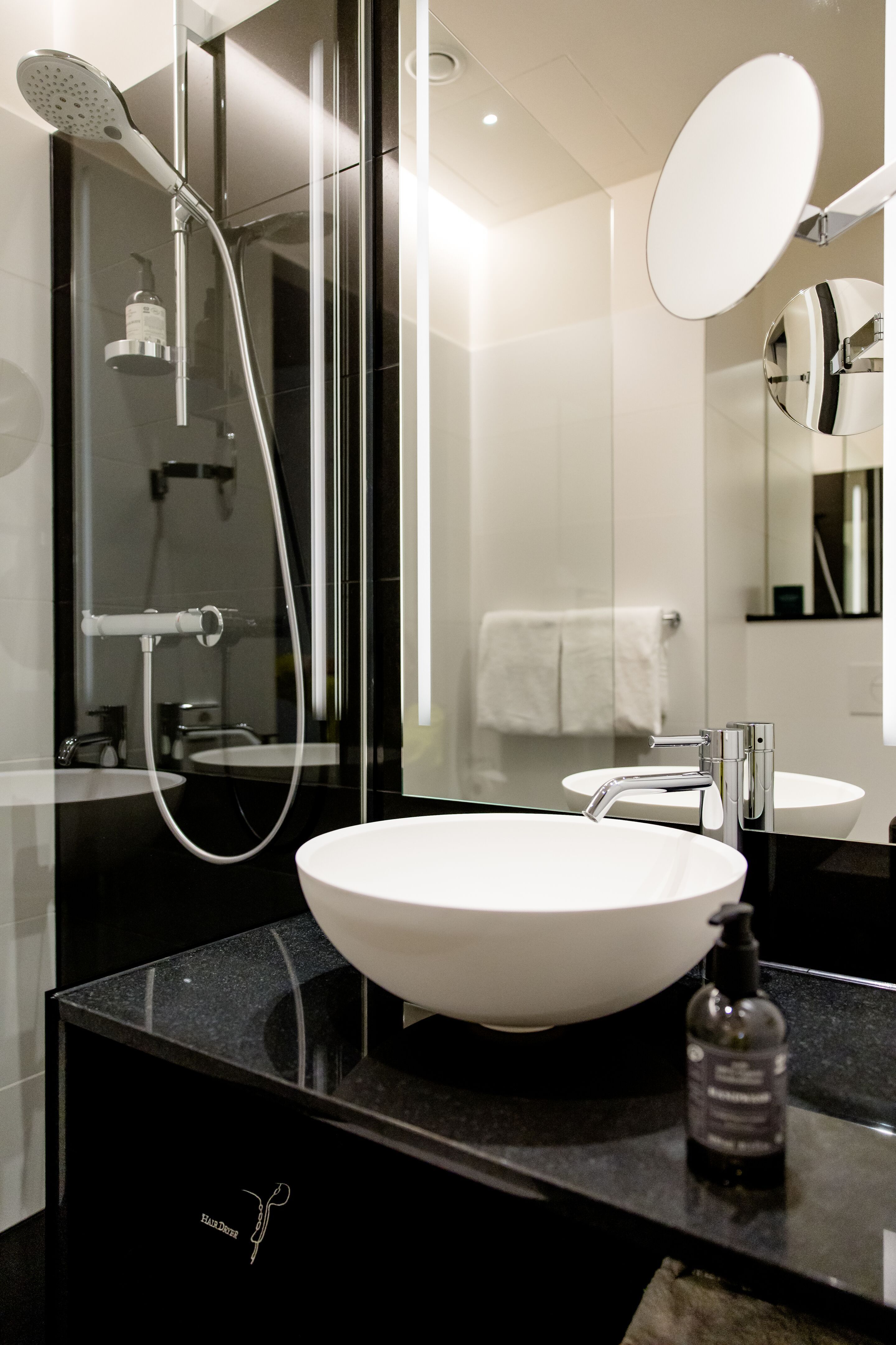 Hotel Wien Donau City Motel One Bad mit Blick auf die Dusche, ein Waschbecken sowie einen großen Spiegel Hotel Wien Donau City Motel One Bad mit Blick auf die Dusche, ein Waschbecken sowie einen großen Spiegel