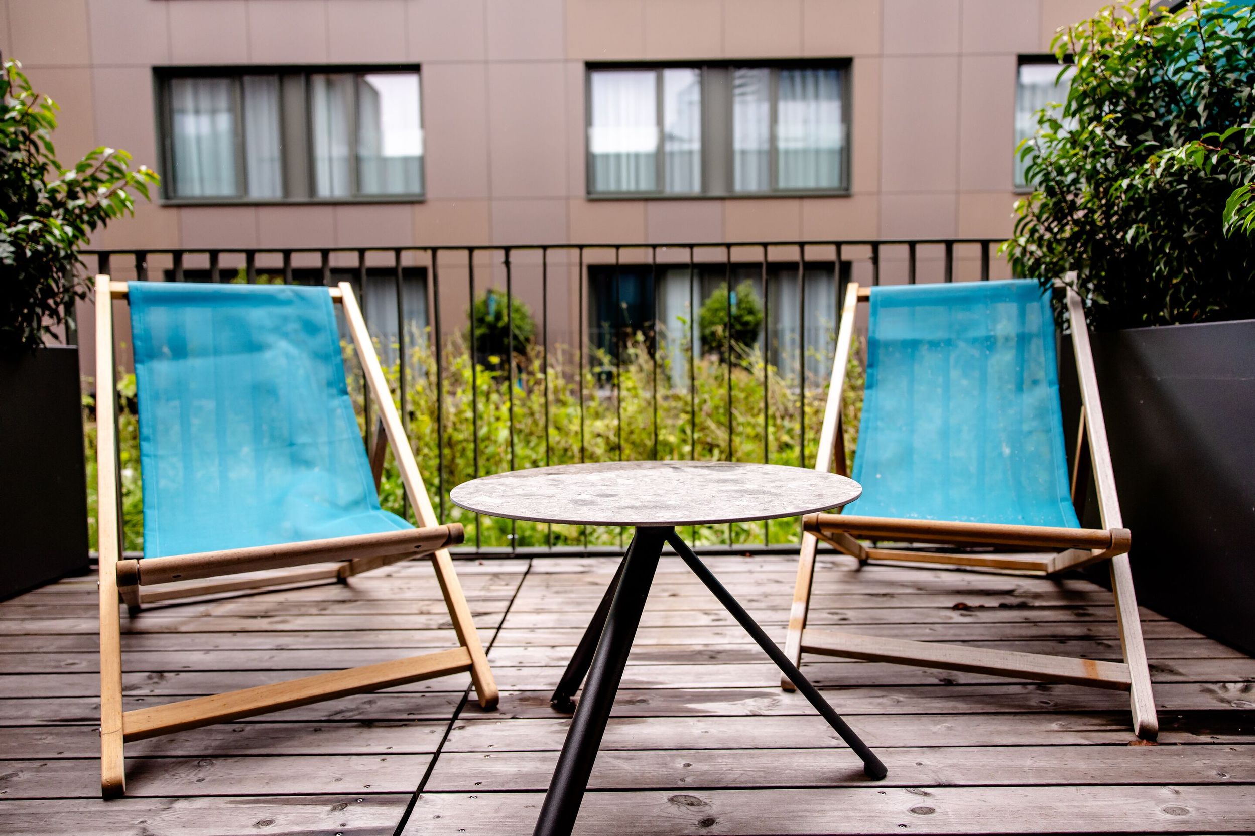 Hotel Wien Donau City Motel One Balkon mit Blick auf zwei Liegestühle in türkis