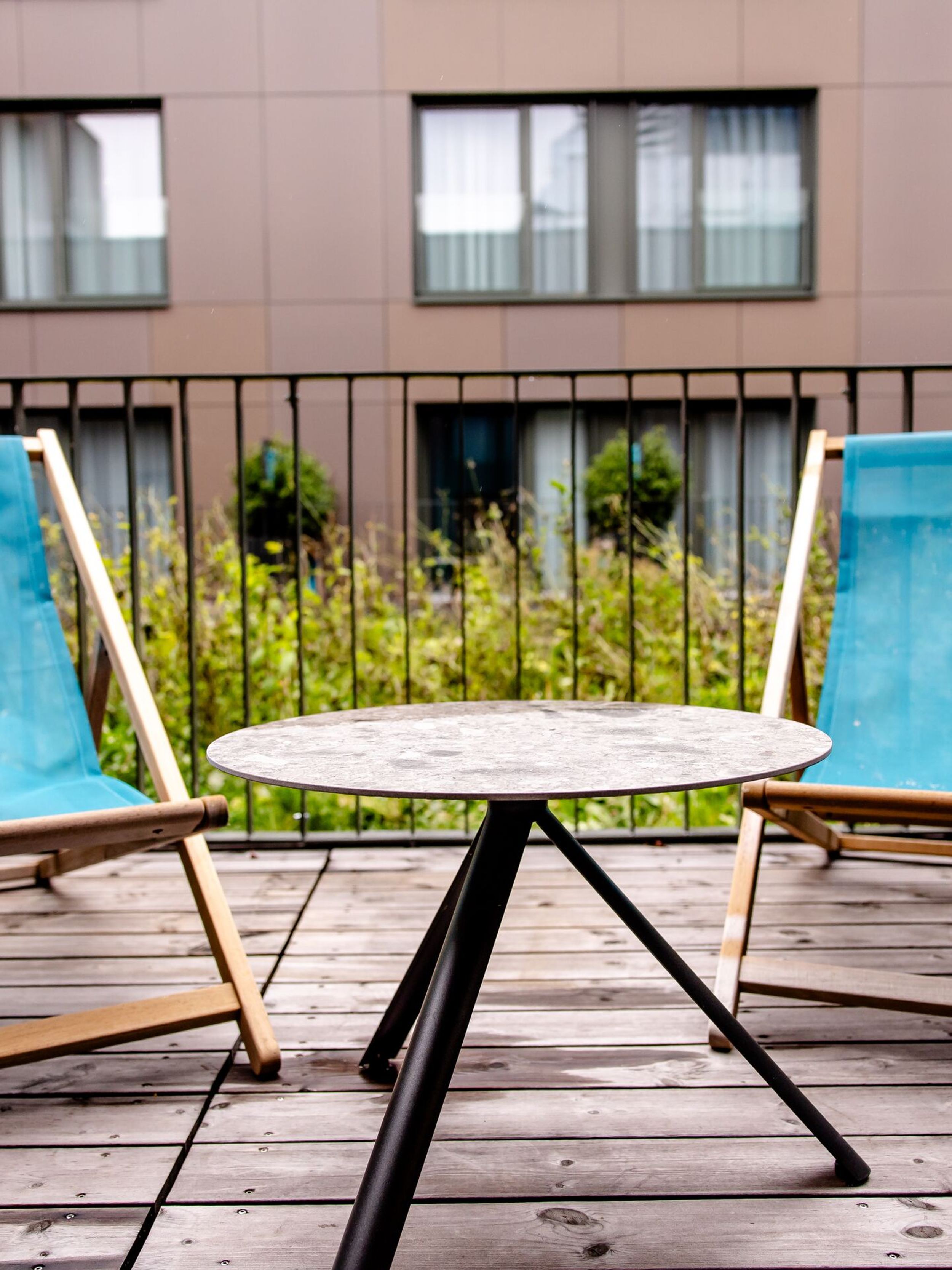 Hotel Wien Donau City Motel One Balkon mit Blick auf zwei Liegestühle in türkis