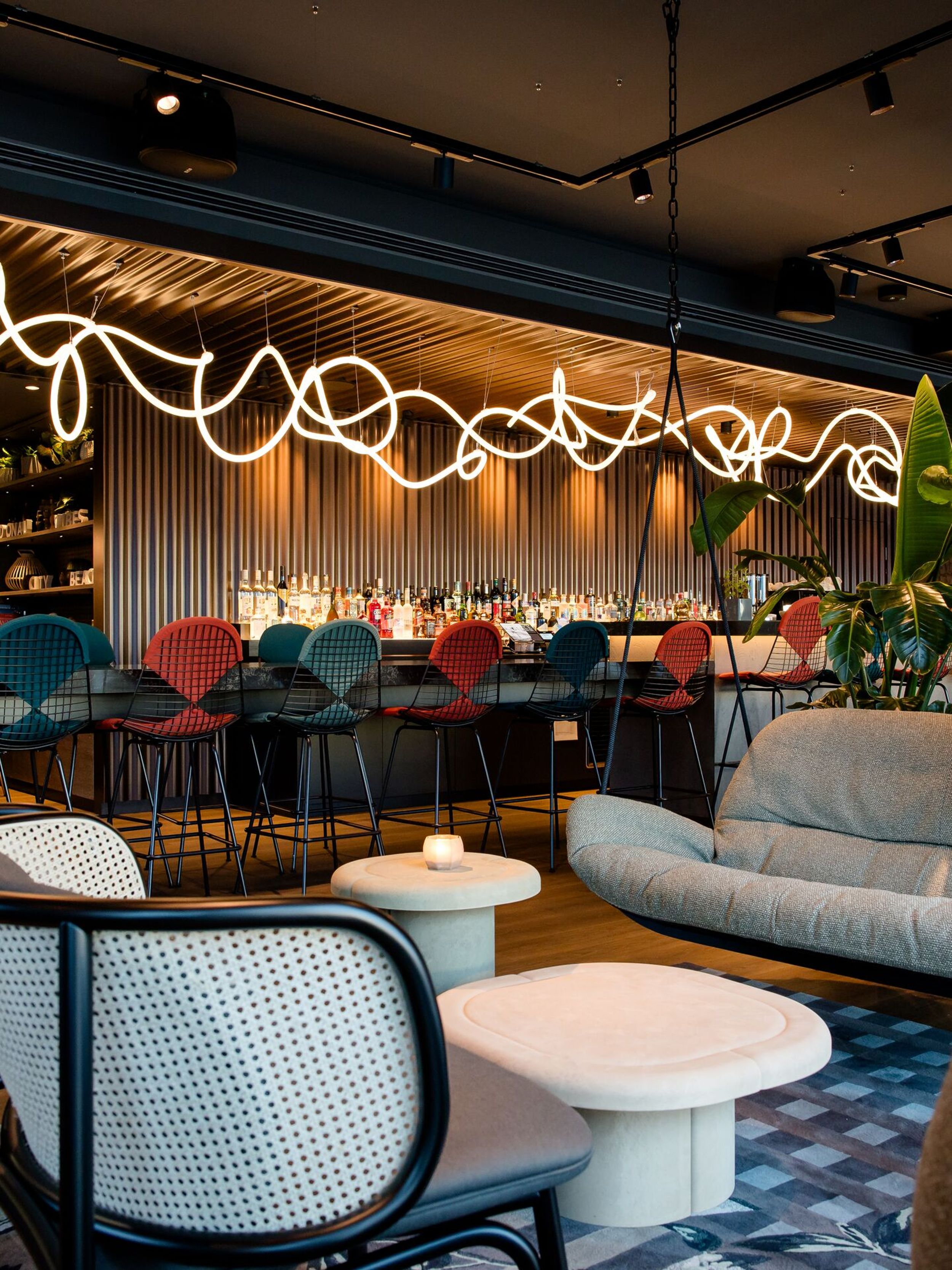 Hotel Wien Donau City Motel One Lounge mit Sesseln und freischwebender Couch sowie Blick auf die Bar