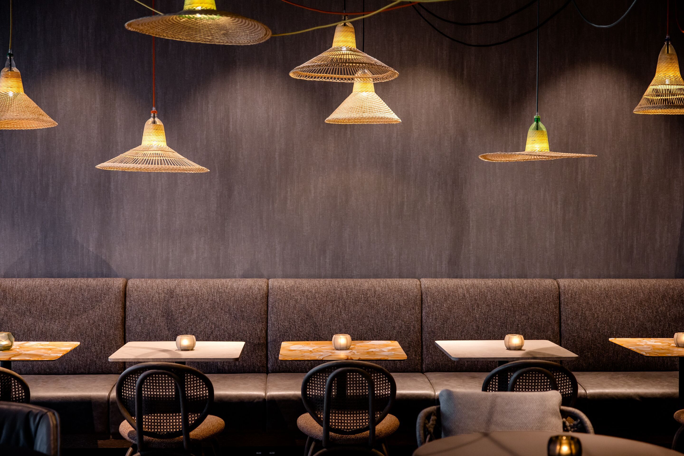 Hotel Wien Donau City Motel One Frühstücksbereich mit Blick auf mehrere Tische und Stühle sowie Deckenlampen in Strohhutdesign