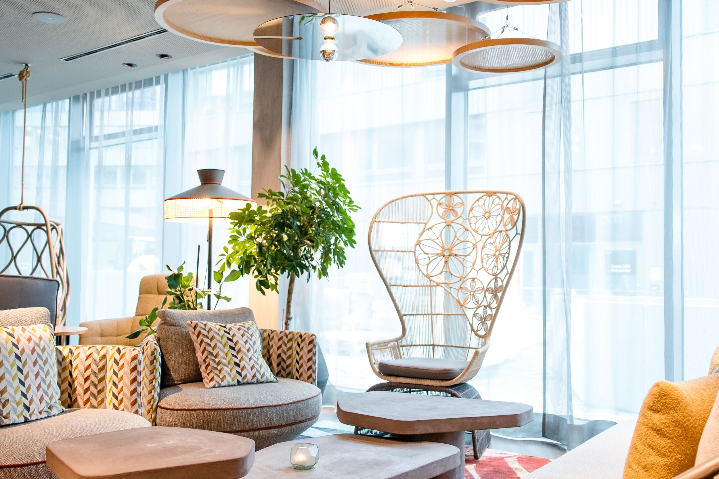 Hotel Wien Donau City Motel One lichtdurchflutete Lounge mit mehreren Sitzgelegenheiten und bodentiefe Fenster