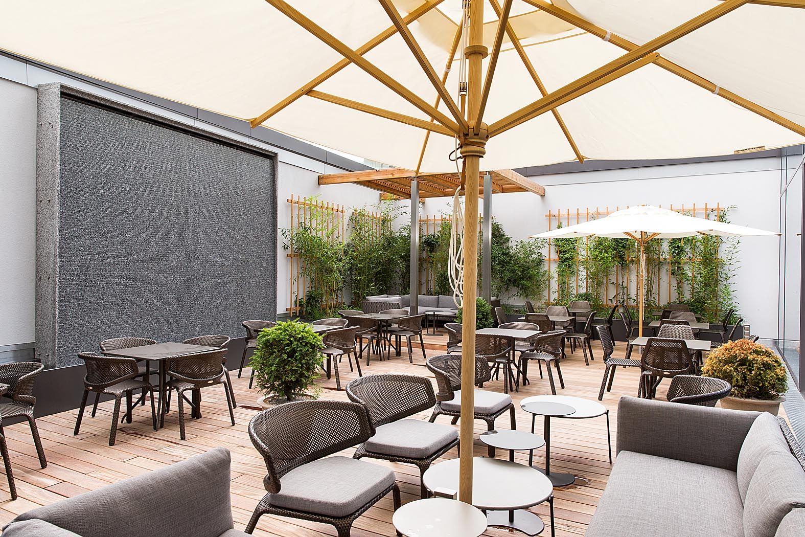 Hotel Wien Hauptbahnhof Motel One Außenbereich mit Sitzmöglichkeiten und Sonnenschirm