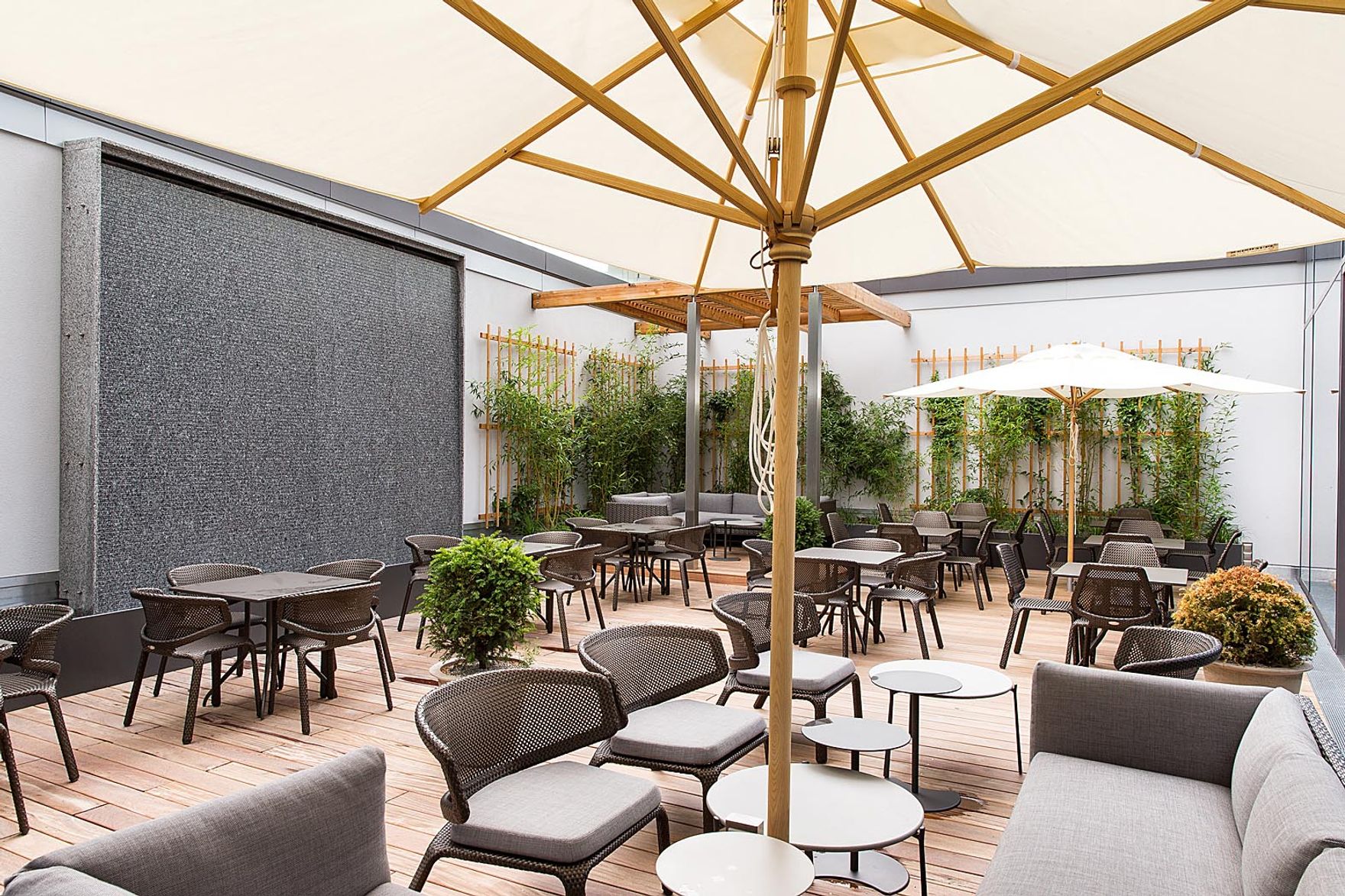 Hotel Wien Hauptbahnhof Motel One Außenbereich mit Sitzmöglichkeiten und Sonnenschirm