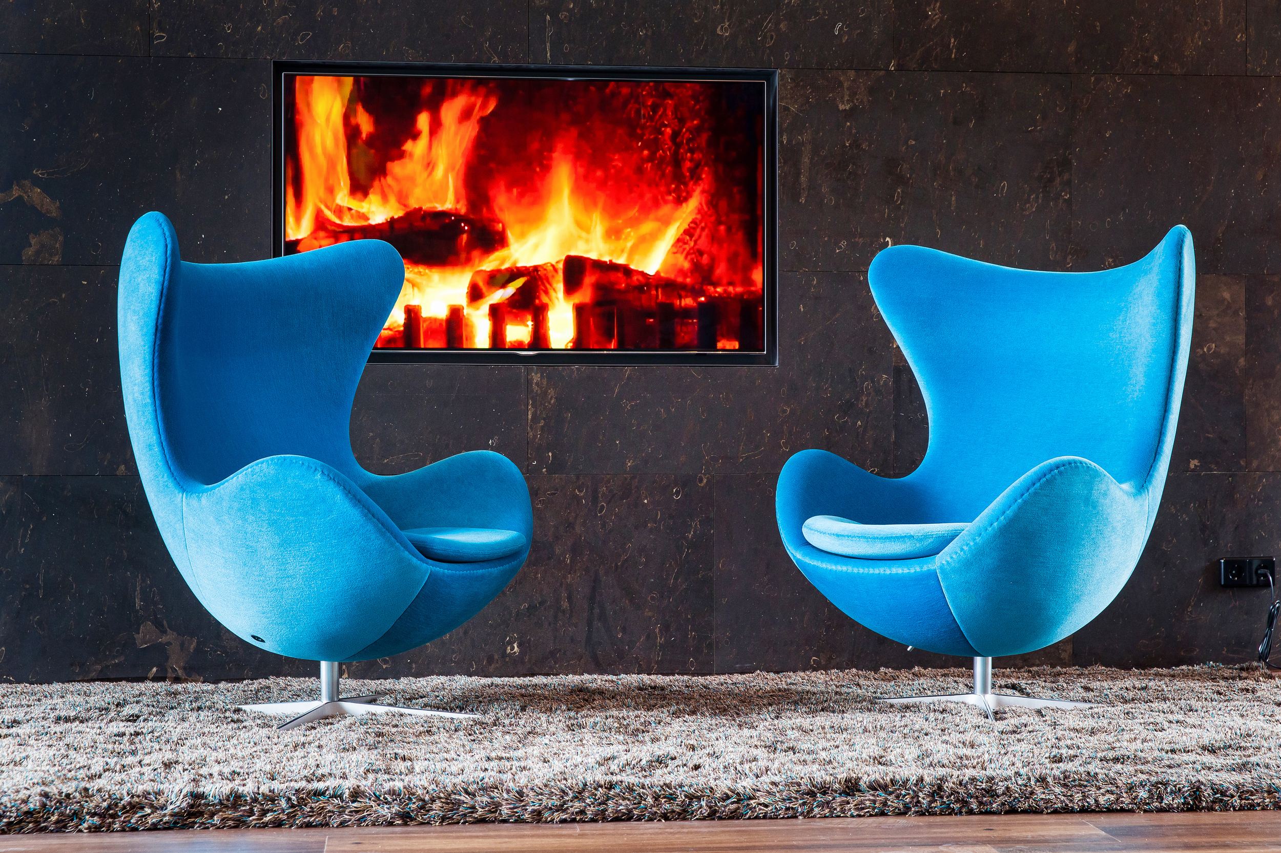Hotel Wien Hauptbahnhof Motel One Eggchairs vor TV mit Feuer